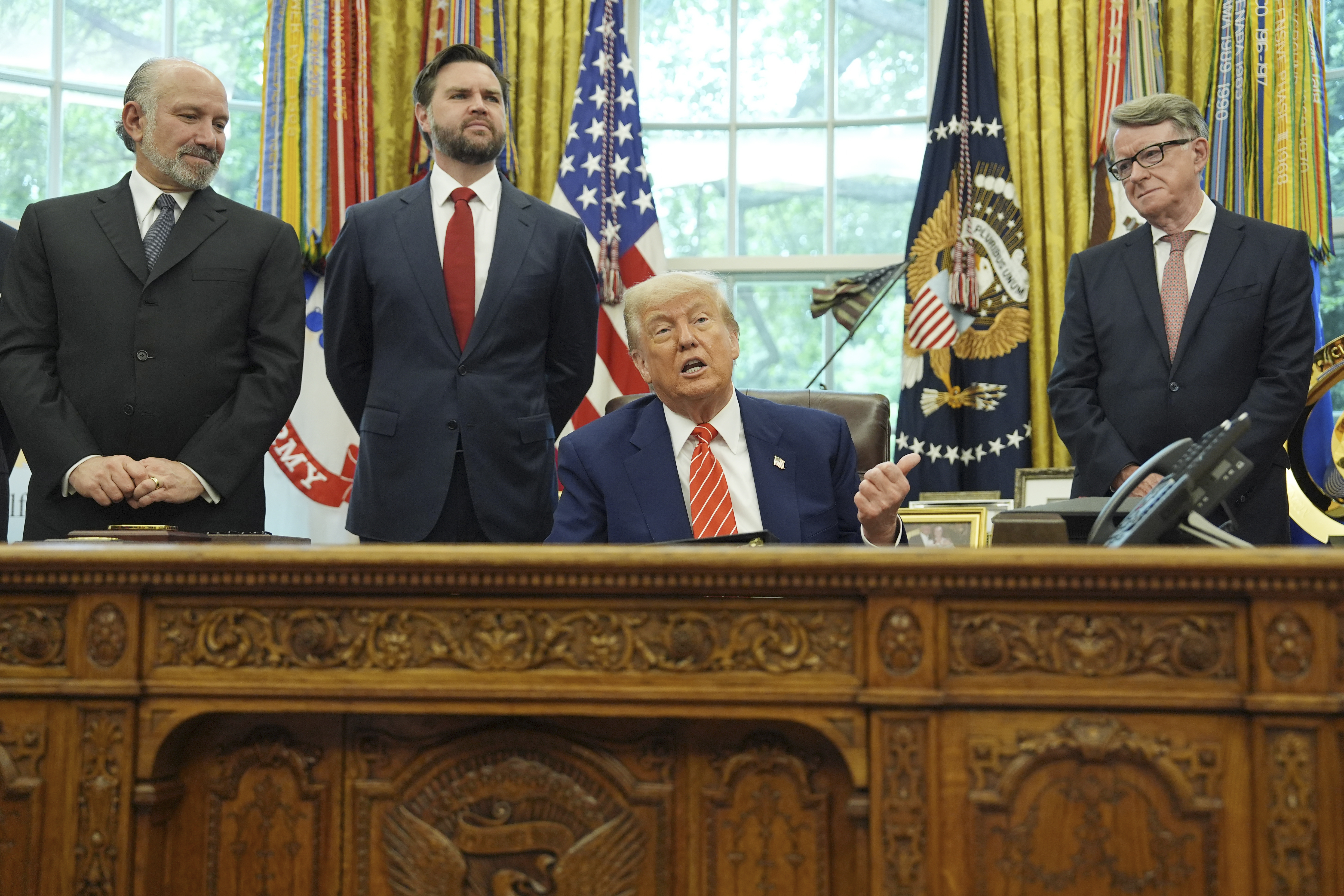 President Donald Trump, center, with from l-r., Commerce Secretary Howard Lutnick, Vice President JD Vance, and Britian's ambassador to the United States Peter Mandelson, making remarks on a trade deal between U.S. and U.K. in the Oval Office of the White House, Thursday, May 8, 2025, in Washington. (AP Photo/Evan Vucci)