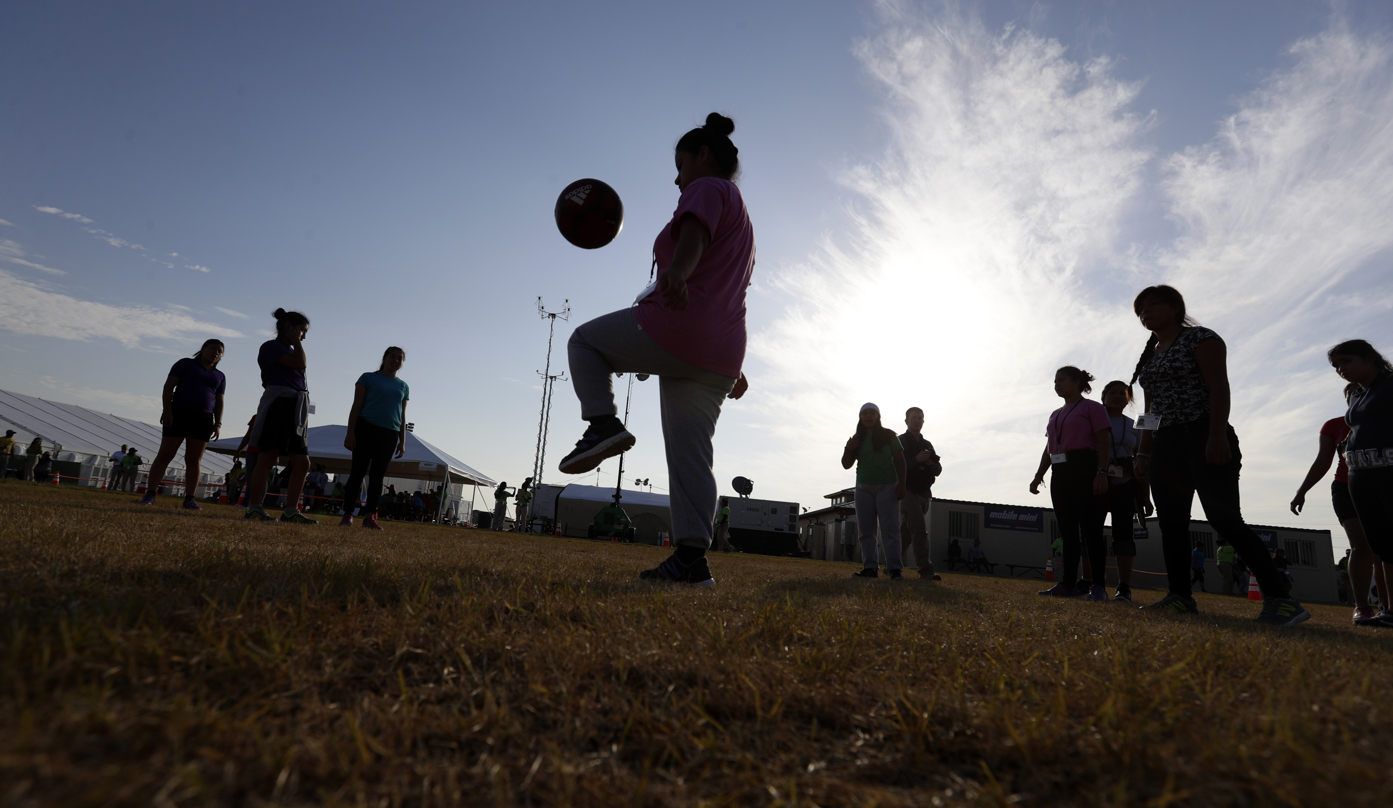 FILE- Immigrants play soccer at the U.S. government holding center for migrant children in Carrizo Springs, Texas, on July 9, 2019. (AP Photo/Eric Gay, File)