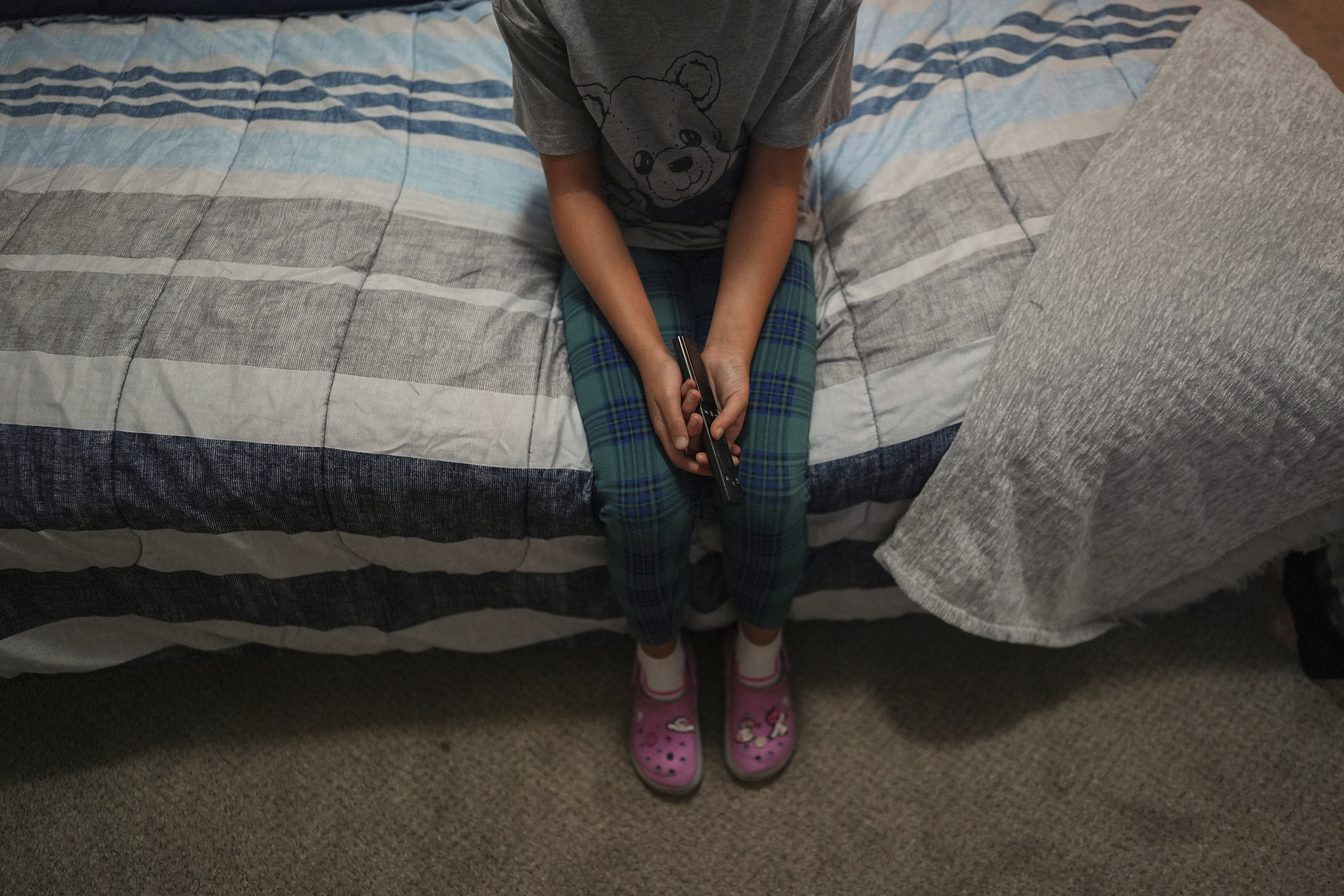 FILE - A 9-year-old girl with Temporary Protected Status, or TPS, who was born in Venezuela, but who fluently speaks only English and is in the gifted program at her school, watches TV in her family's apartment, April 5, 2025, in Doral, Fla. (AP Photo/Rebecca Blackwell, File)