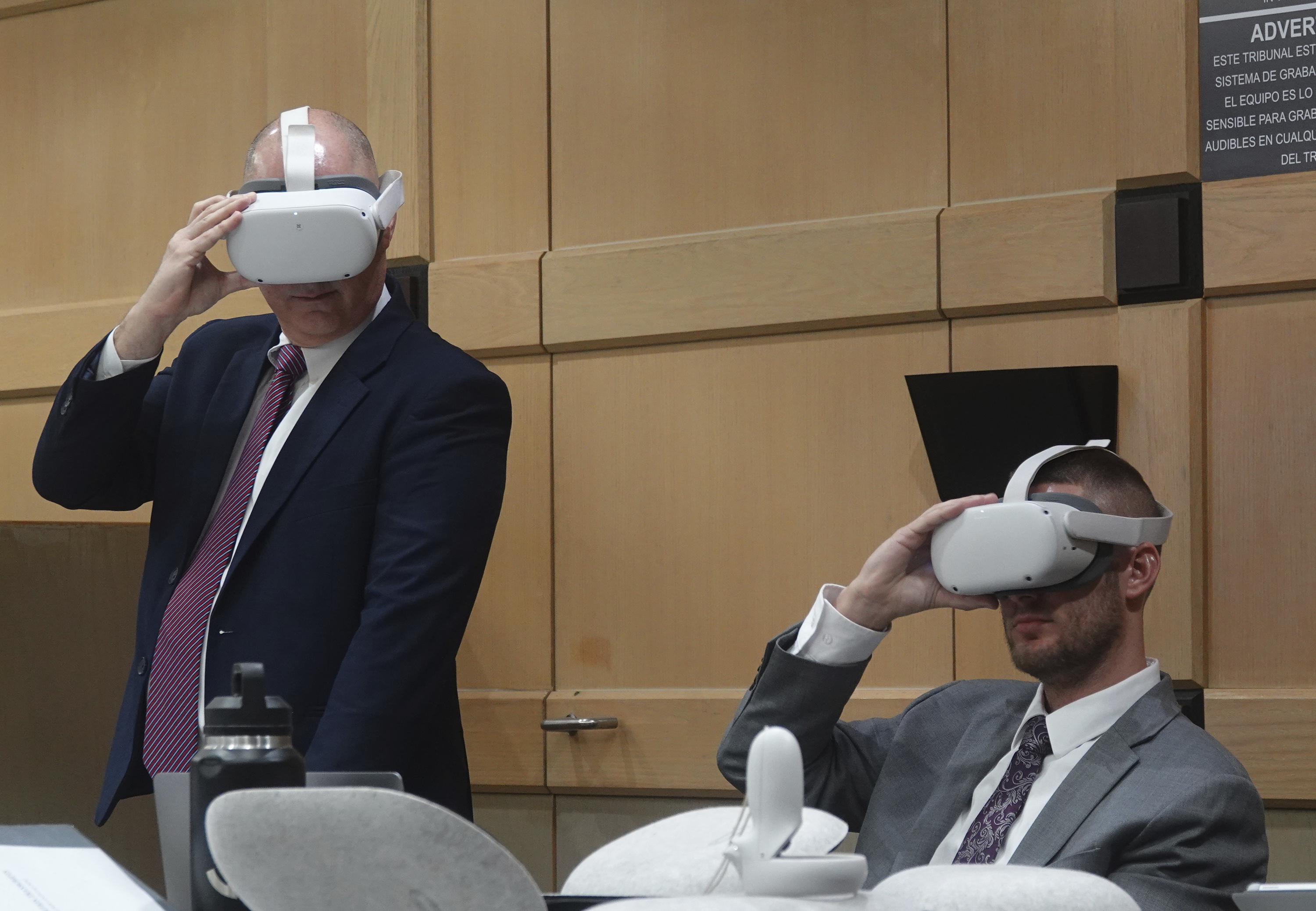Defense attorneys Ken and Jason Padowitz watch a virtual reality presentation, Thursday, Dec. 17, 2024, at the Broward County Courthouse in Fort Lauderdale during a hearing on the admissibility of a virtual reality depiction in a stand-your-ground case. Miguel Rodriguez Albisu, 59, owner of a wedding venue in Southwest Ranches, is accused of pulling a gun on wedding guests who did not leave after he said they were supposed to. (Joe Cavaretta/South Florida Sun Sentinel via AP)