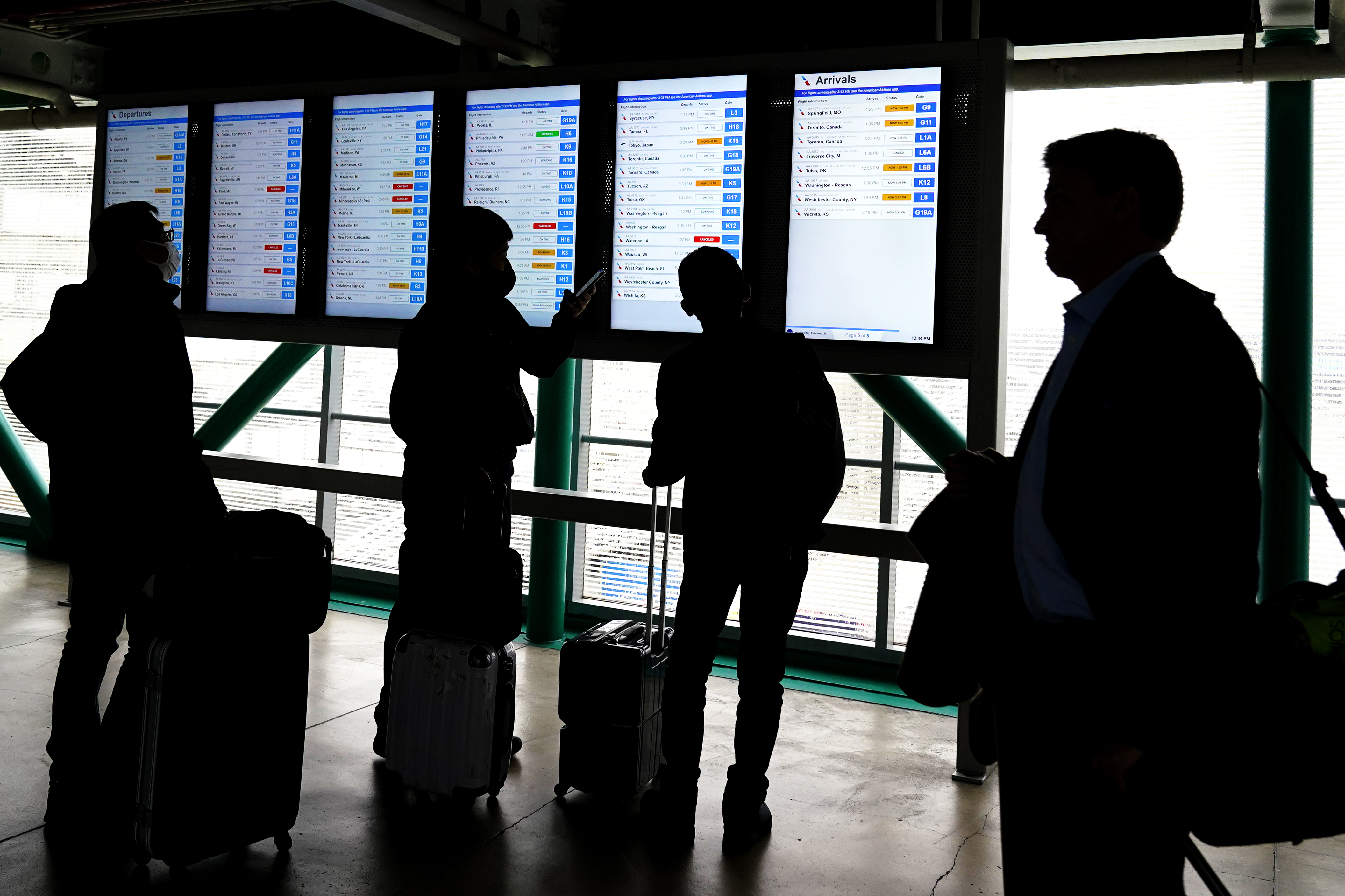 FILE - Travelers check American Airlines flight information screens for their flight status at O'Hare International Airport in Chicago, Wednesday, Feb. 22, 2023. (AP photo/Nam Y. Huh, File)