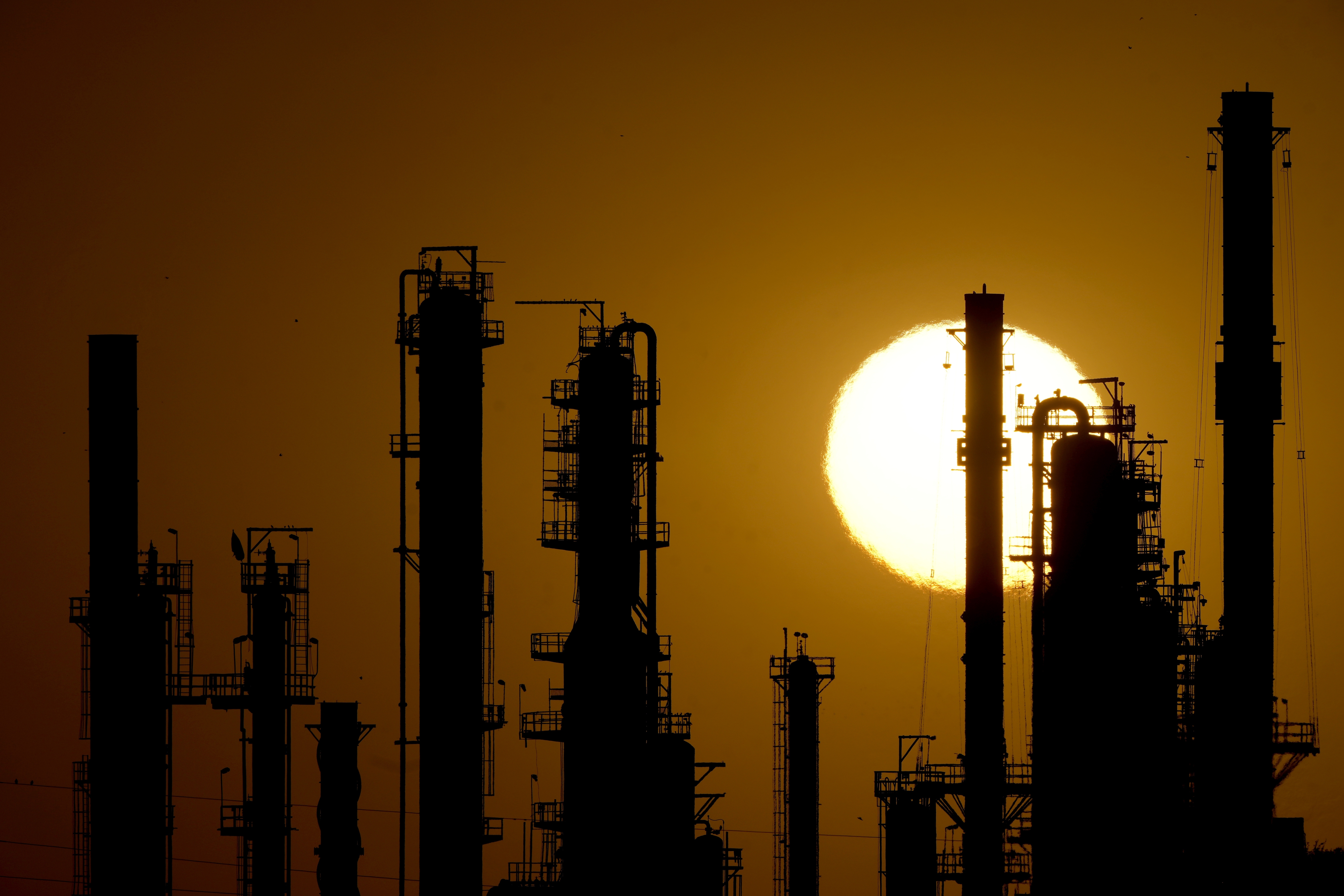 FILE - The CHS oil refinery is silhouetted against the setting sun, Sept. 28, 2024, in McPherson, Kan. (AP Photo/Charlie Riedel, file)
