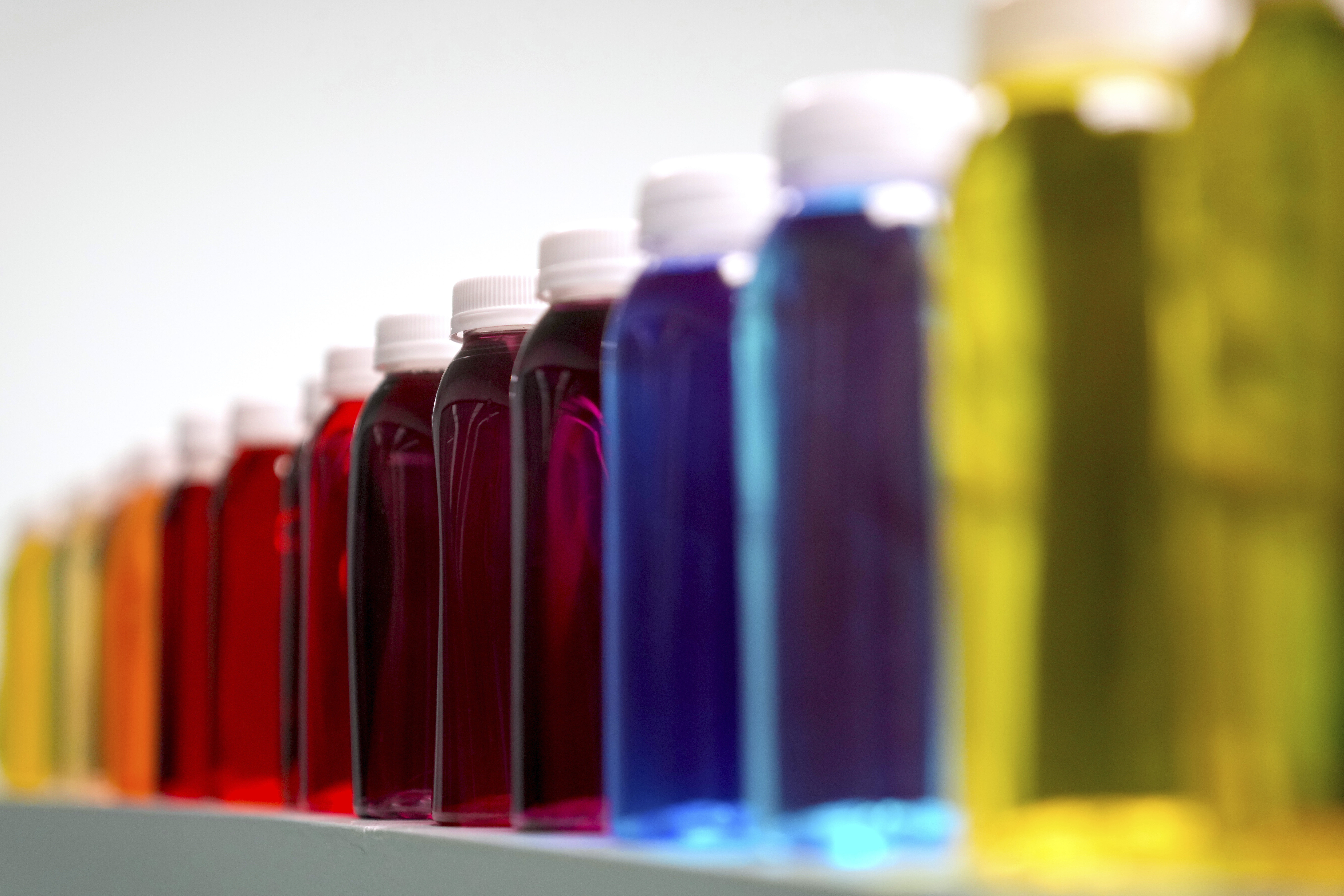 FILE - Bottles containing a variety of colored liquids sit on a shelf in a lab at Sensient Technologies Corp., a color additive manufacturing company, in St. Louis., on Wednesday, April 2, 2025. (AP Photo/Jeff Roberson, File)