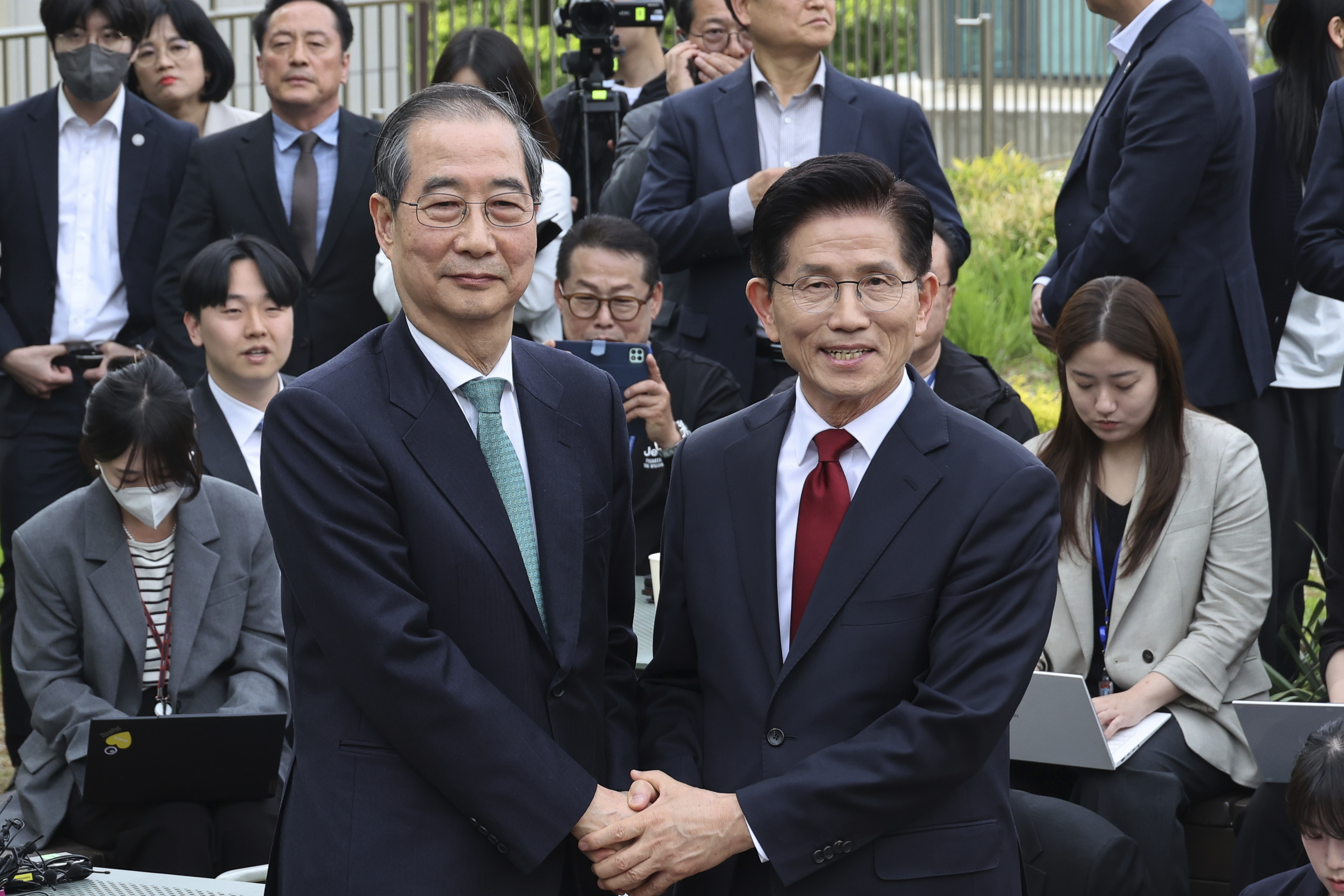 South Korea's People Power Party's presidential election candidate Kim Moon Soo, right, and independent preliminary presidential election candidate Han Duck-soo pose for a photo during a meeting in Seoul, South Korea, Thursday, May 8, 2025. (Yonhap via AP)