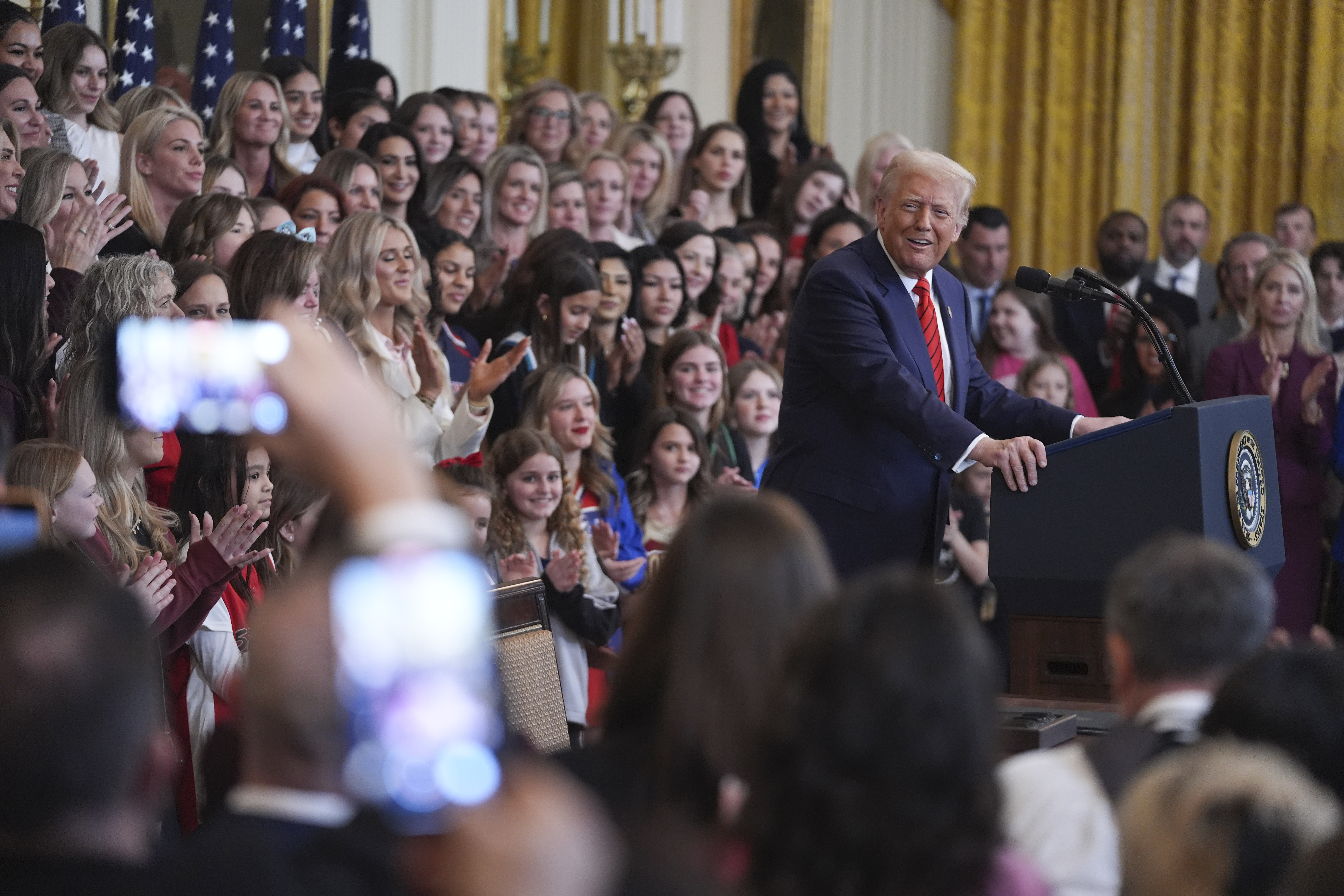 FILE - Women and girls look on as President Donald Trump speaks before signing an executive order barring transgender female athletes from competing in women's or girls' sporting events, in the East Room of the White House, Wednesday, Feb. 5, 2025, in Washington.(AP Photo/ Evan Vucci, File)