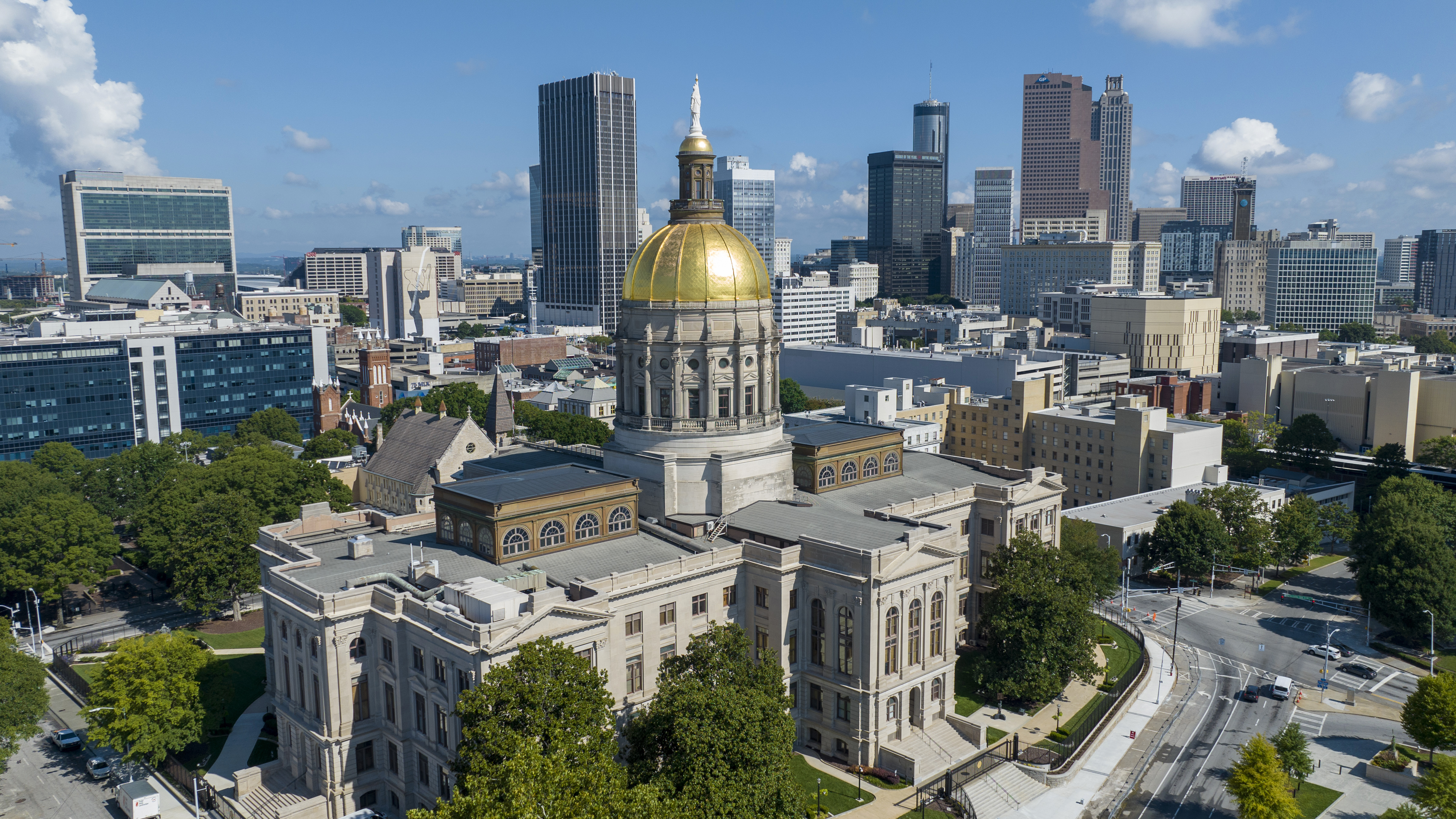 FILE - The gold dome of the Georgia Capitol gleams in the sun, Aug. 27, 2022, in front of the skyline of downtown Atlanta. (AP Photo/Steve Helber, File)