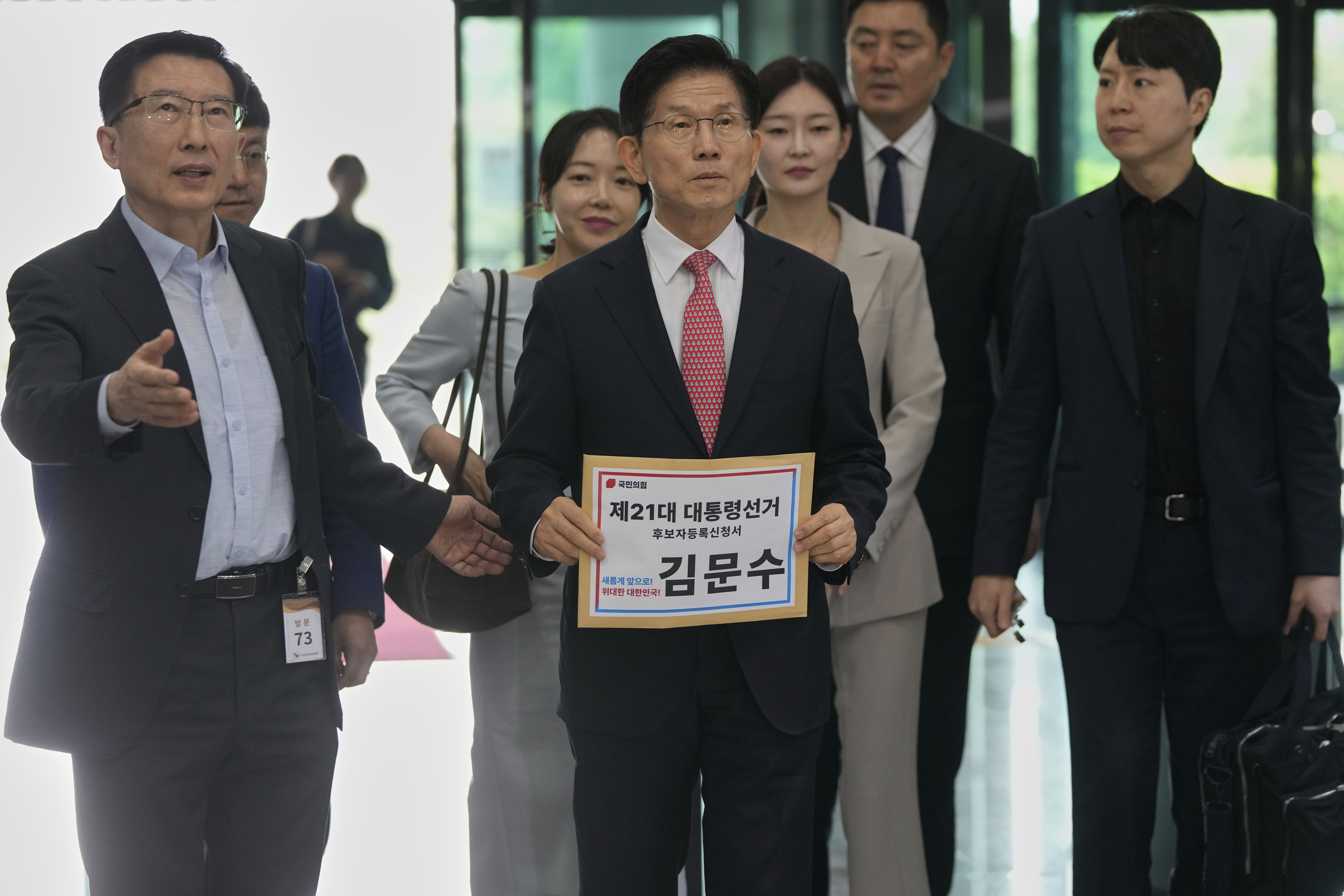 South Korea's People Power Party's presidential election candidate Kim Moon Soo, center, arrives to submit documents to register as a candidate to run in the June 3 presidential election, at the National Election Commission, Gwacheon, South Korea, Sunday, May 11, 2025. The letter read "The 21st Presidential election candidate registration application, Kim Moon Soo."(AP Photo/Ahn Young-joon)