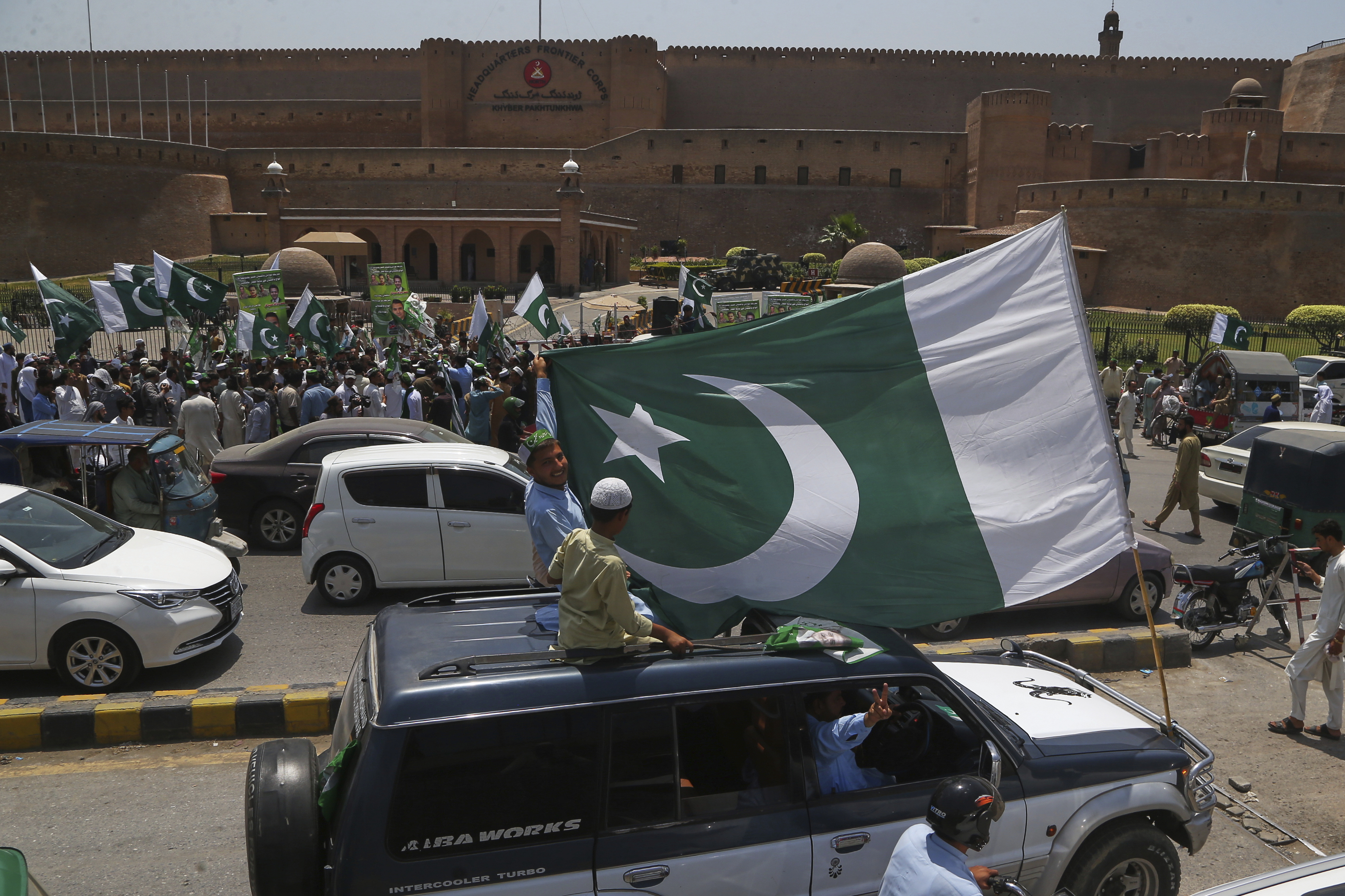 People with national flags take part in a demonstration to show their support with Pakistan Army, a day after the ceasefire between Indian and Pakistan was announced, in Peshawar, Pakistan, Sunday, May 11, 2025. (AP Photo/Muhammad Sajjad)