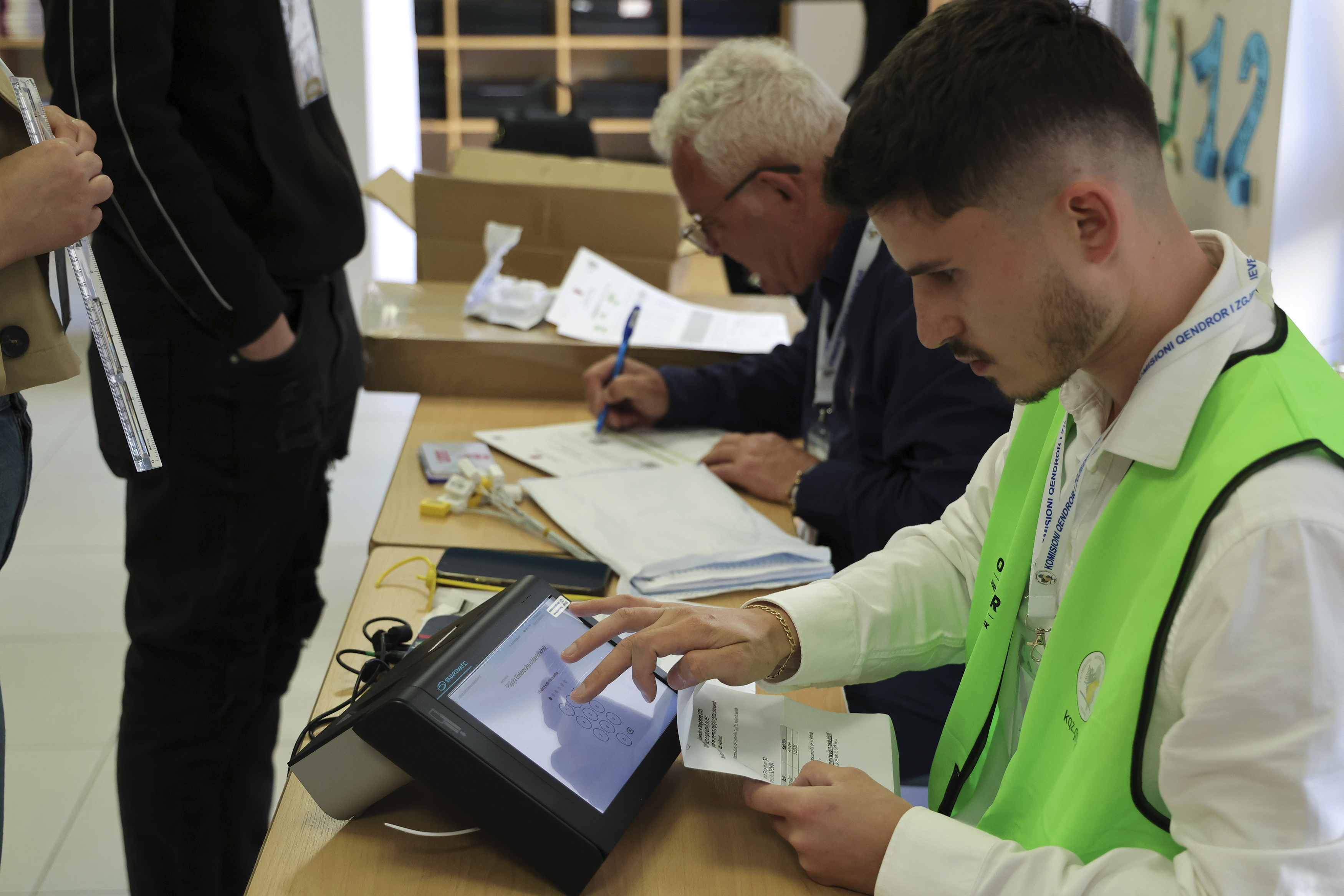 A man checks documents during a general election in Tirana, Albania Sunday, May 11, 2025. (AP Photo/Vlasov Sulaj)