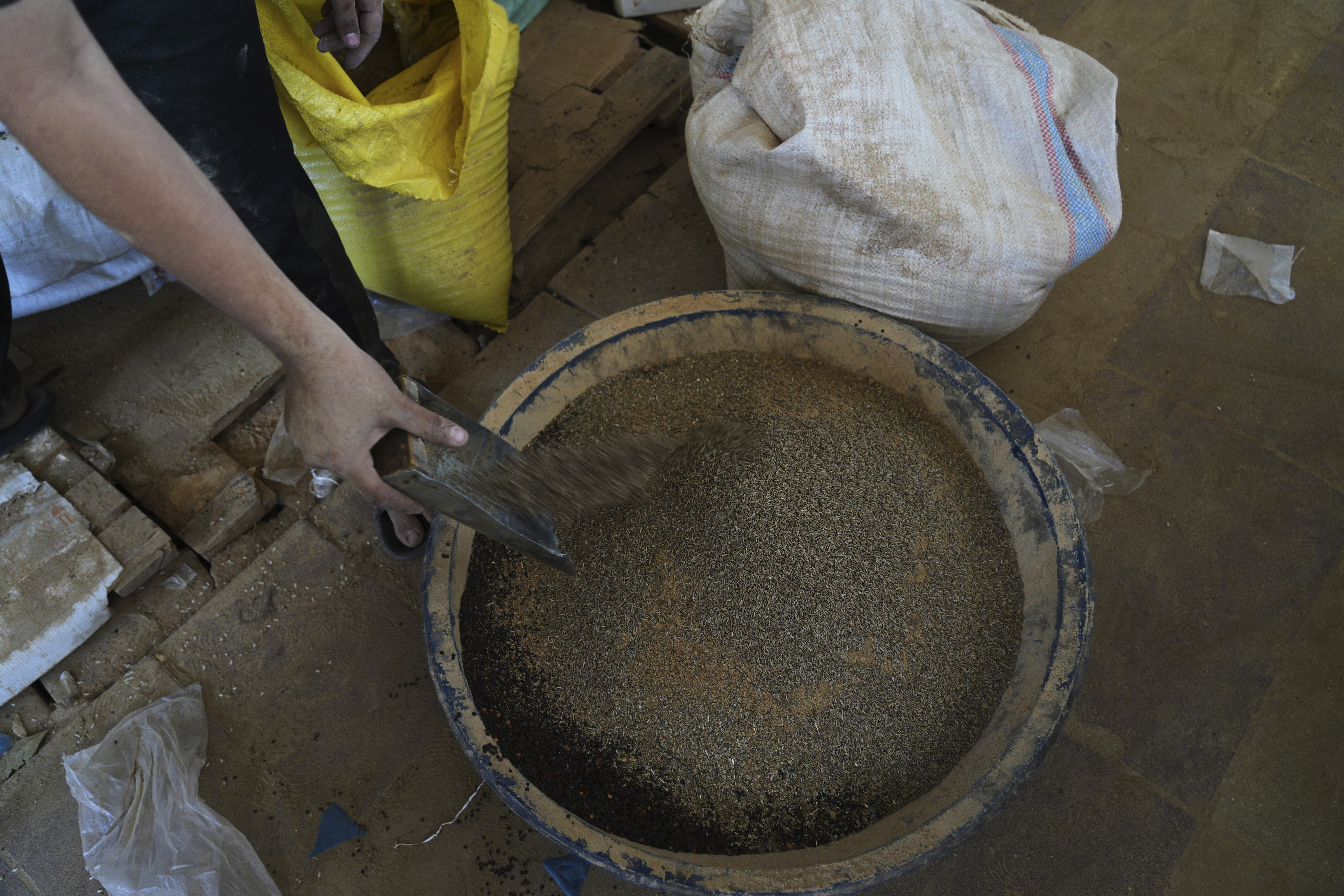 Displaced Palestinians purchase ground lentils as a substitute for making bread due to a shortage of flour in the Gaza Strip, in Khan Younis, on Sunday, May 11, 2025. (AP Photo/Abdel Karem Hanna)