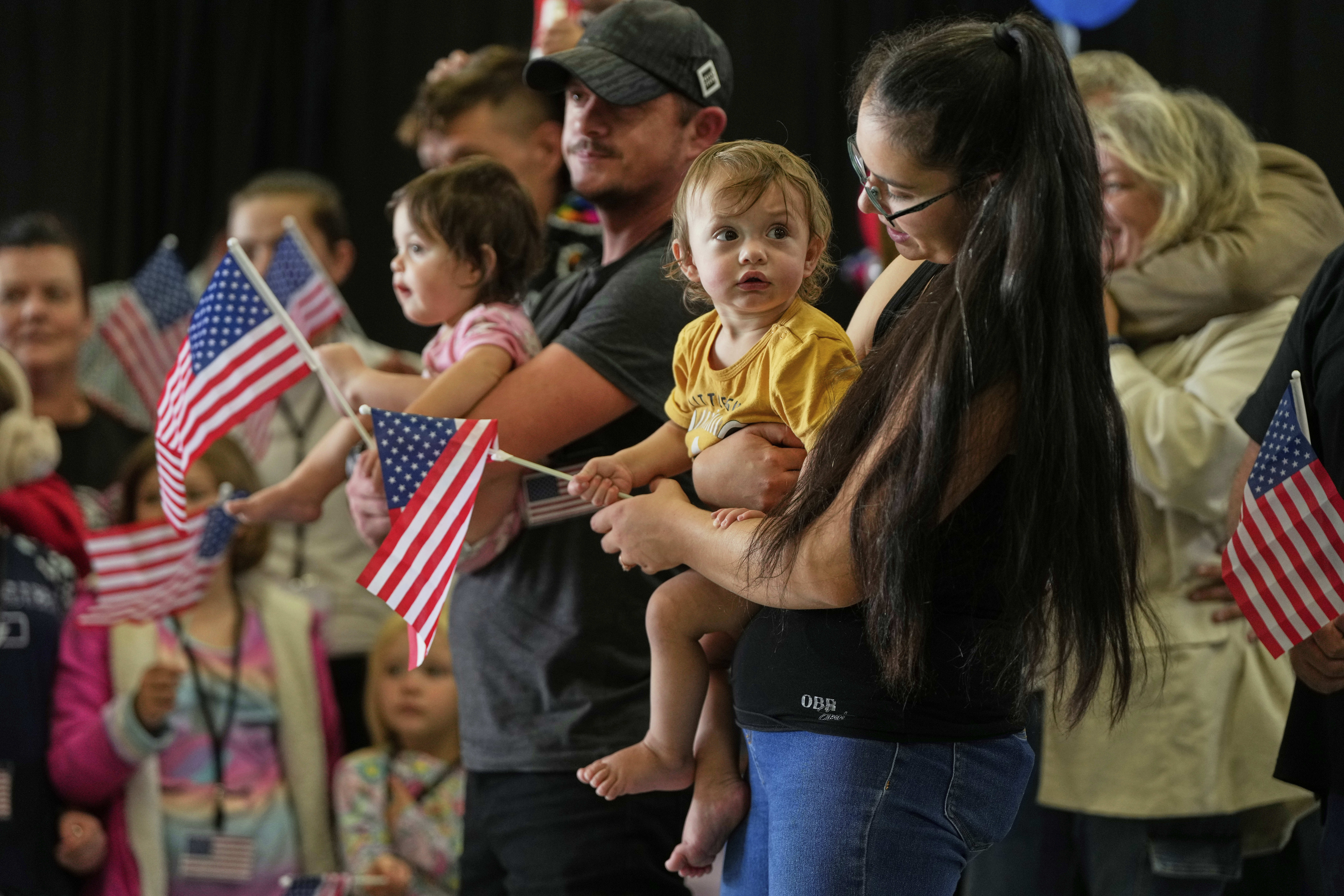 Afrikaner refugees from South Africa holding American flags arrive, Monday, May 12, 2025, at Dulles International Airport in Dulles, Va. (AP Photo/Julia Demaree Nikhinson)