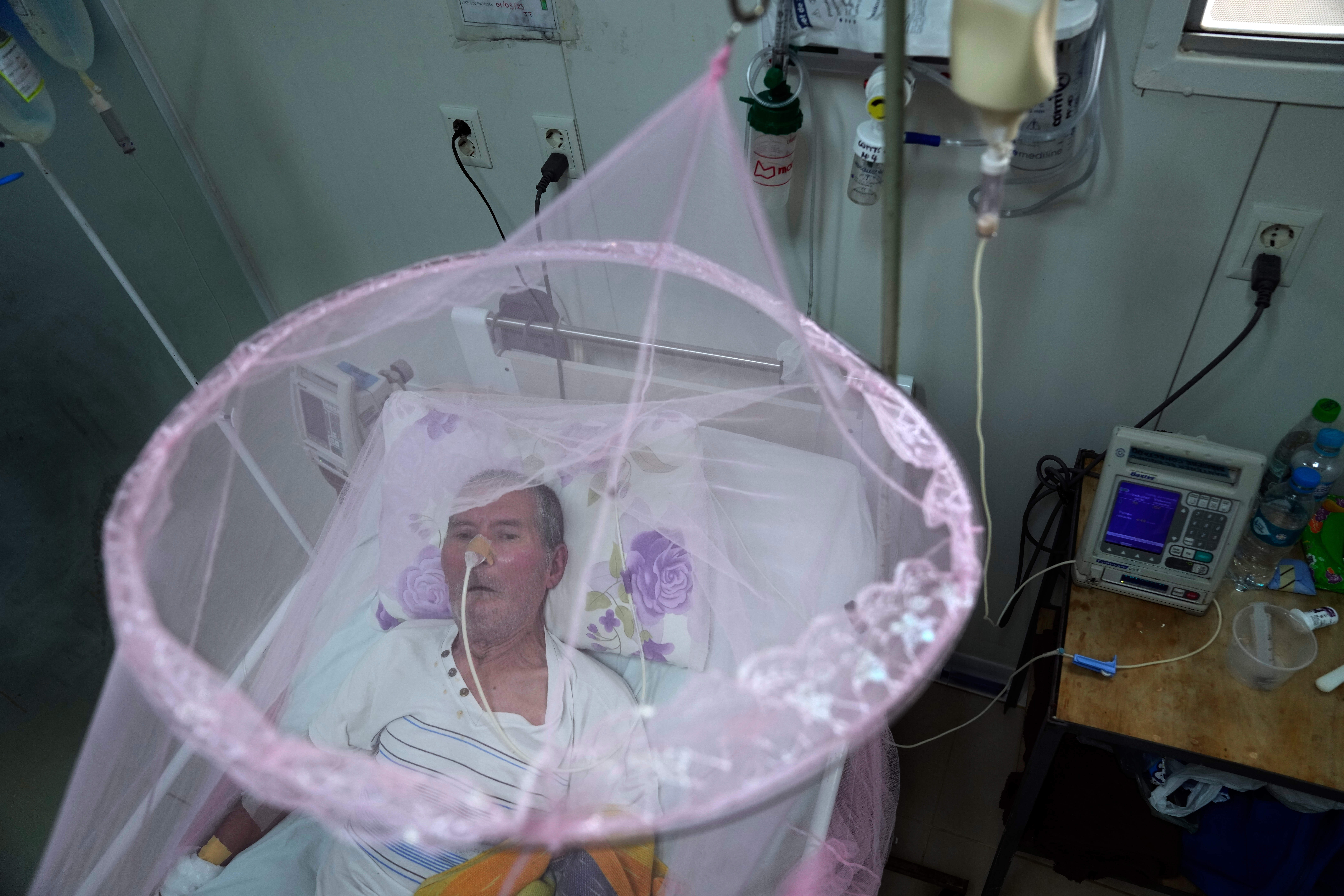 FILE - A patient infected with chikungunya looks out from mosquito netting at the Clinicas Hospital in San Lorenzo, Paraguay, Friday, March 3, 2023. (AP Photo/Jorge Saenz, file)