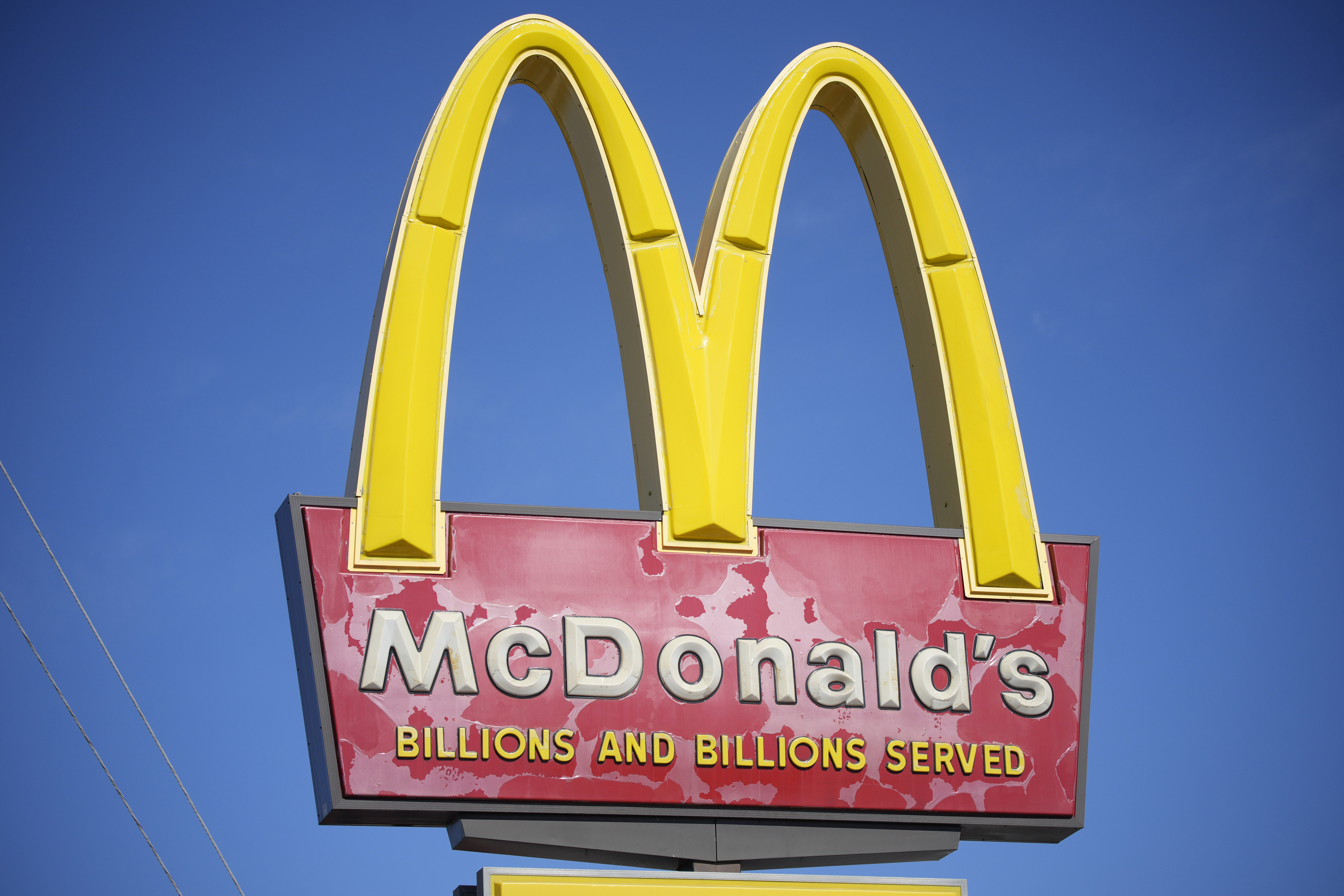 FILE - A sign with the company logo stands over a McDonalds restaurant on South Colorado Boulevard in Denver, Sunday, Oct. 24, 2021. (AP Photo/David Zalubowski, file)