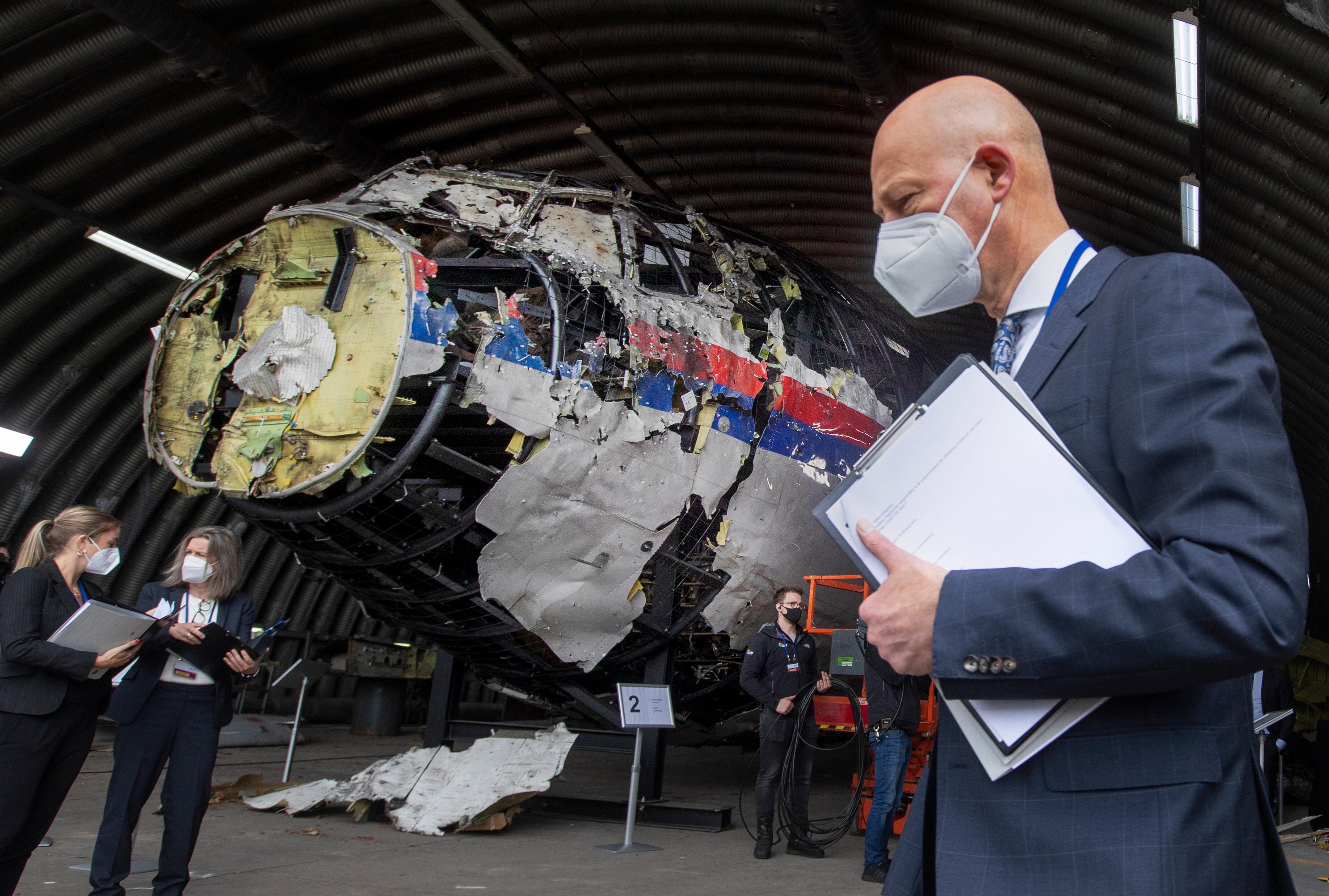 FILE - Presiding judge Hendrik Steenhuis, right, other trial judges and lawyers view the reconstructed wreckage of Malaysia Airlines Flight MH17, at the Gilze-Rijen military airbase, southern Netherlands, on May 26, 2021. (AP Photo/Peter Dejong, Pool, File)