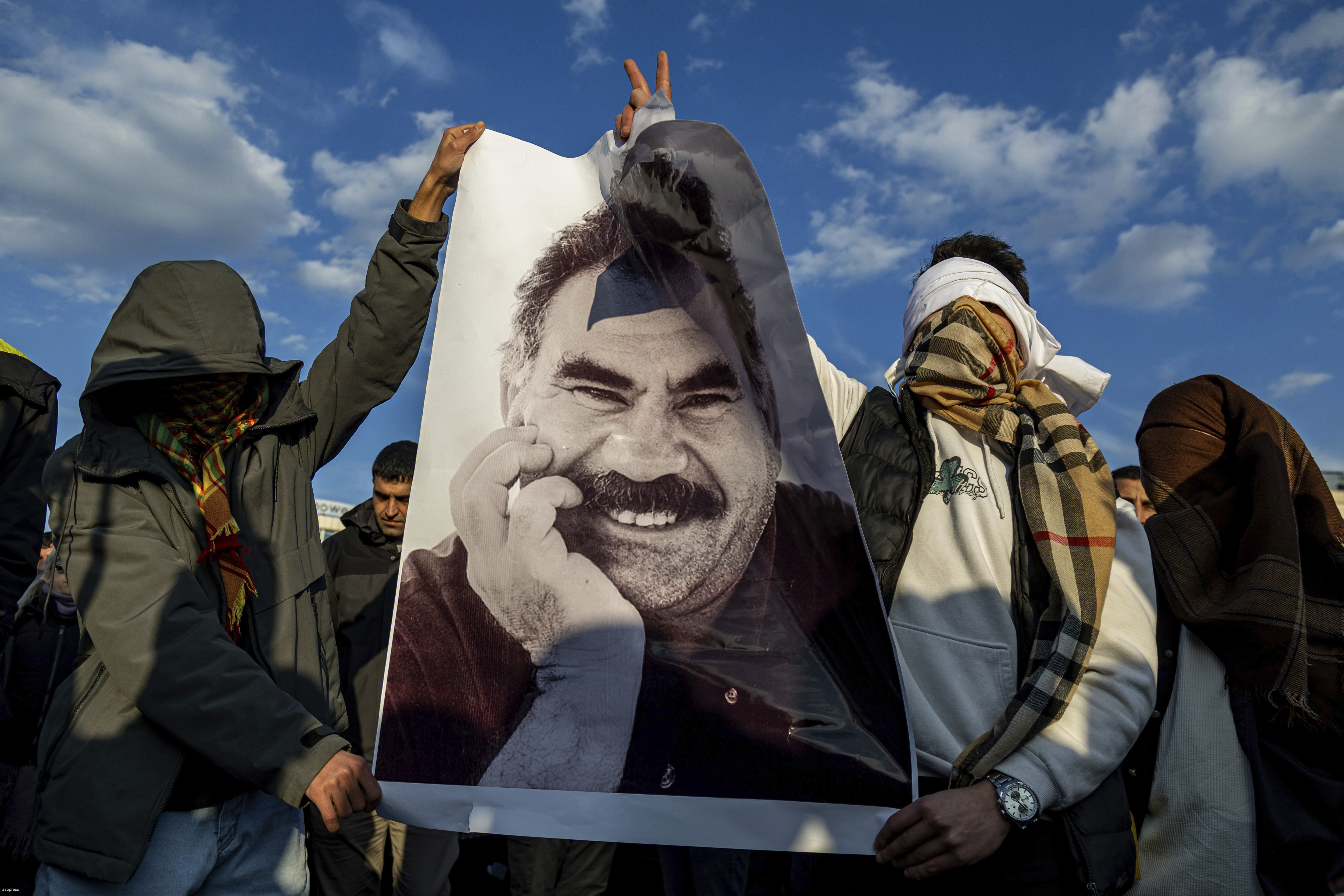 FILE - Youngsters hold a photograph of Abdullah Ocalan, the jailed leader of the militant Kurdish group, or PKK, in Diyarbakir, Turkey, Feb. 27, 2025. (AP Photo/Metin Yoksu, File)