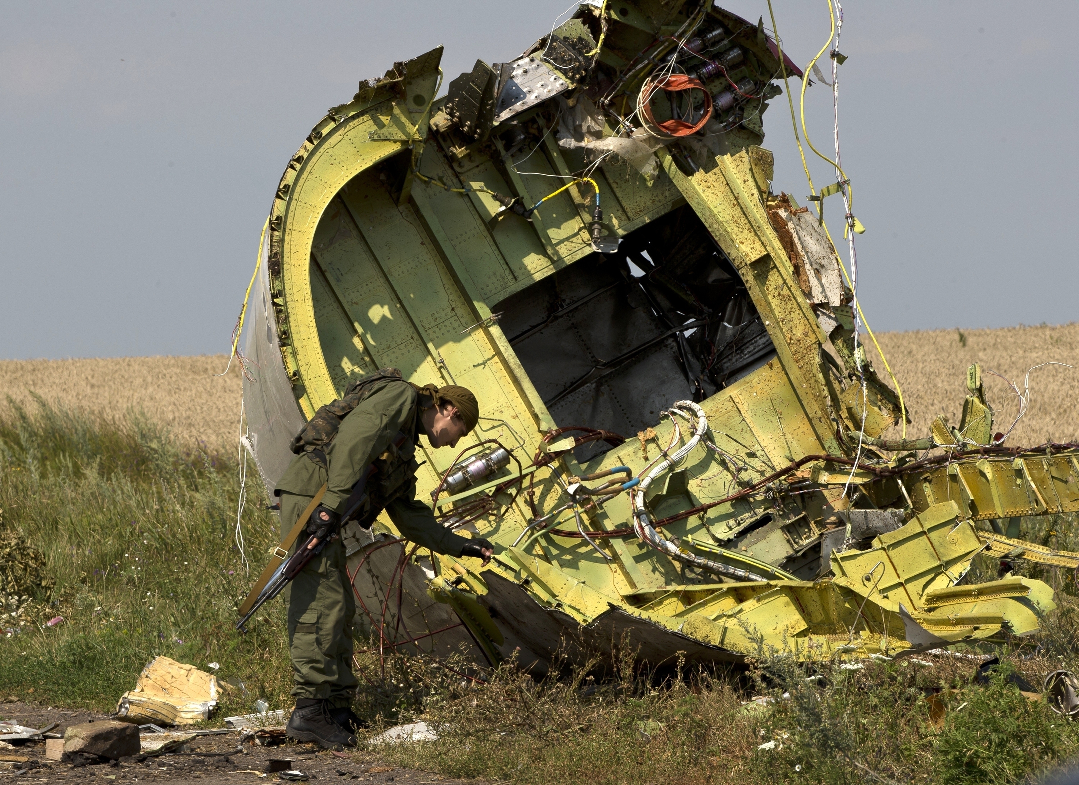 FILE - A pro-Russian rebel touches the MH17 wreckage at the crash site of Malaysia Airlines Flight 17, near the village of Hrabove, eastern Ukraine, on July 22, 2014. (AP Photo/Vadim Ghirda, File)