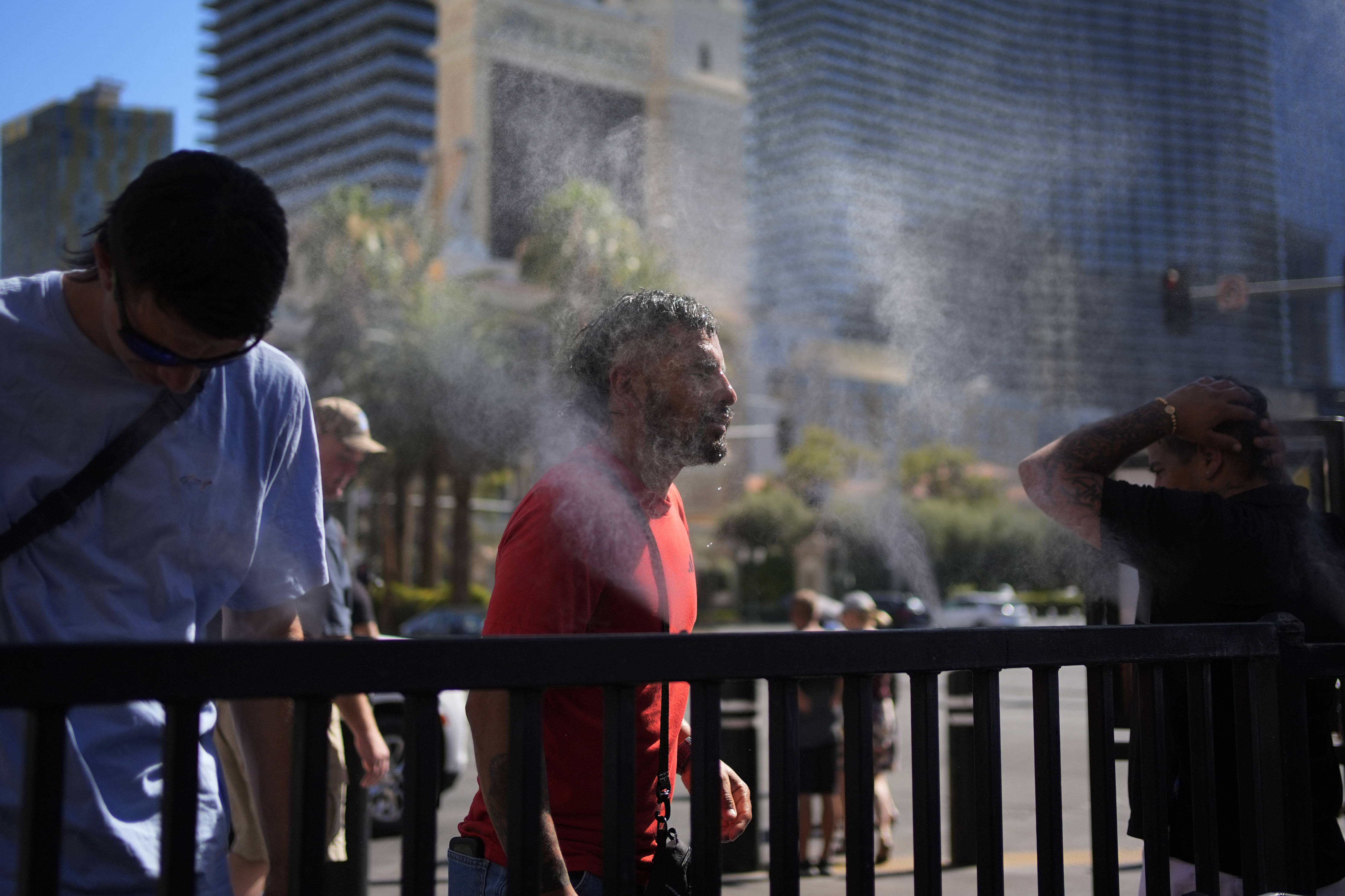 FILE - People cool off in misters during a heat wave along the Las Vegas Strip, Sunday, July 7, 2024, in Las Vegas. (AP Photo/John Locher, file)