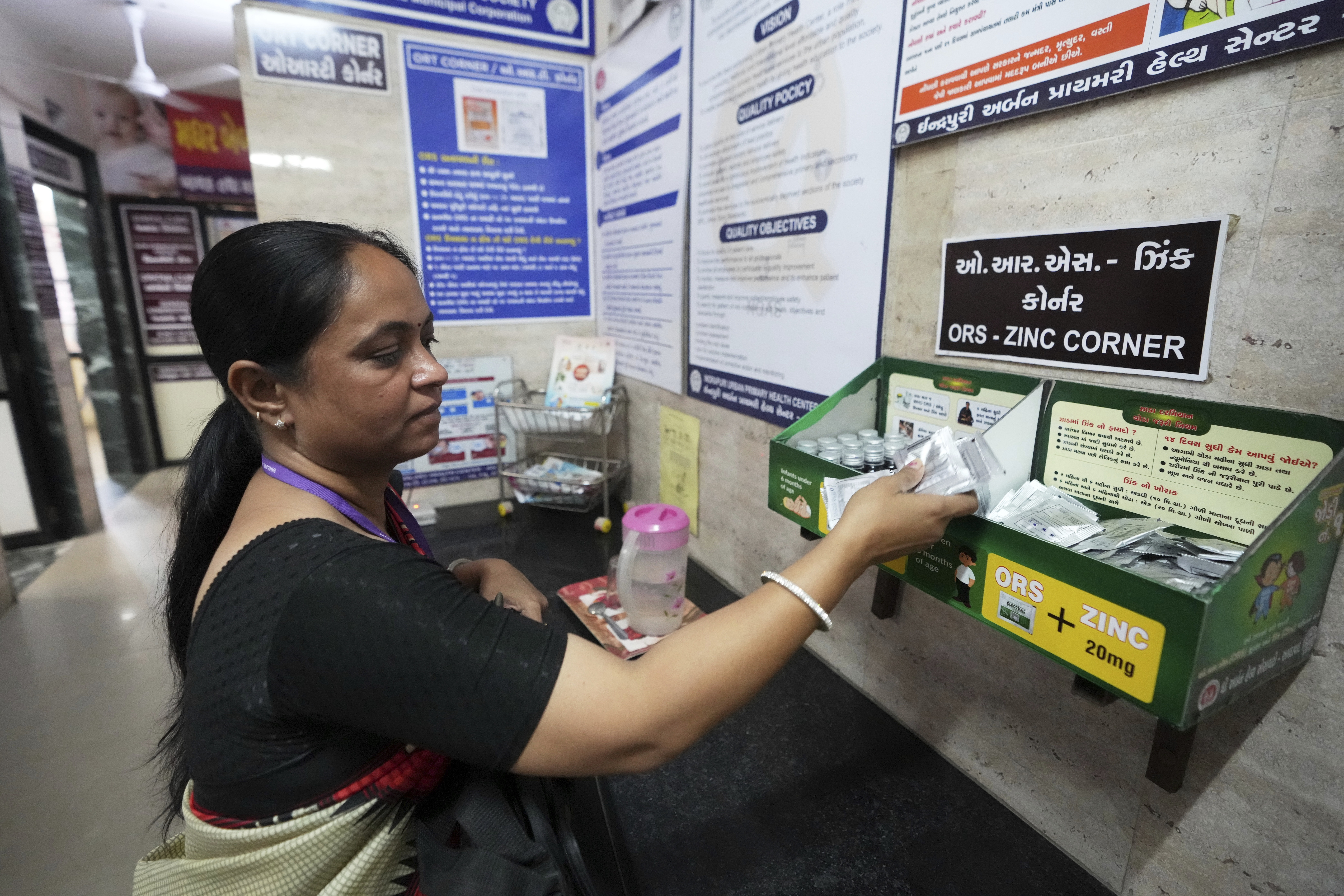 Asha worker Shashi Mishra collects oral rehydration solution pouches before leaving for her job from an urban health center in Ahmedabad, India, Wednesday, April 2, 2025. (AP Photo/Ajit Solanki)