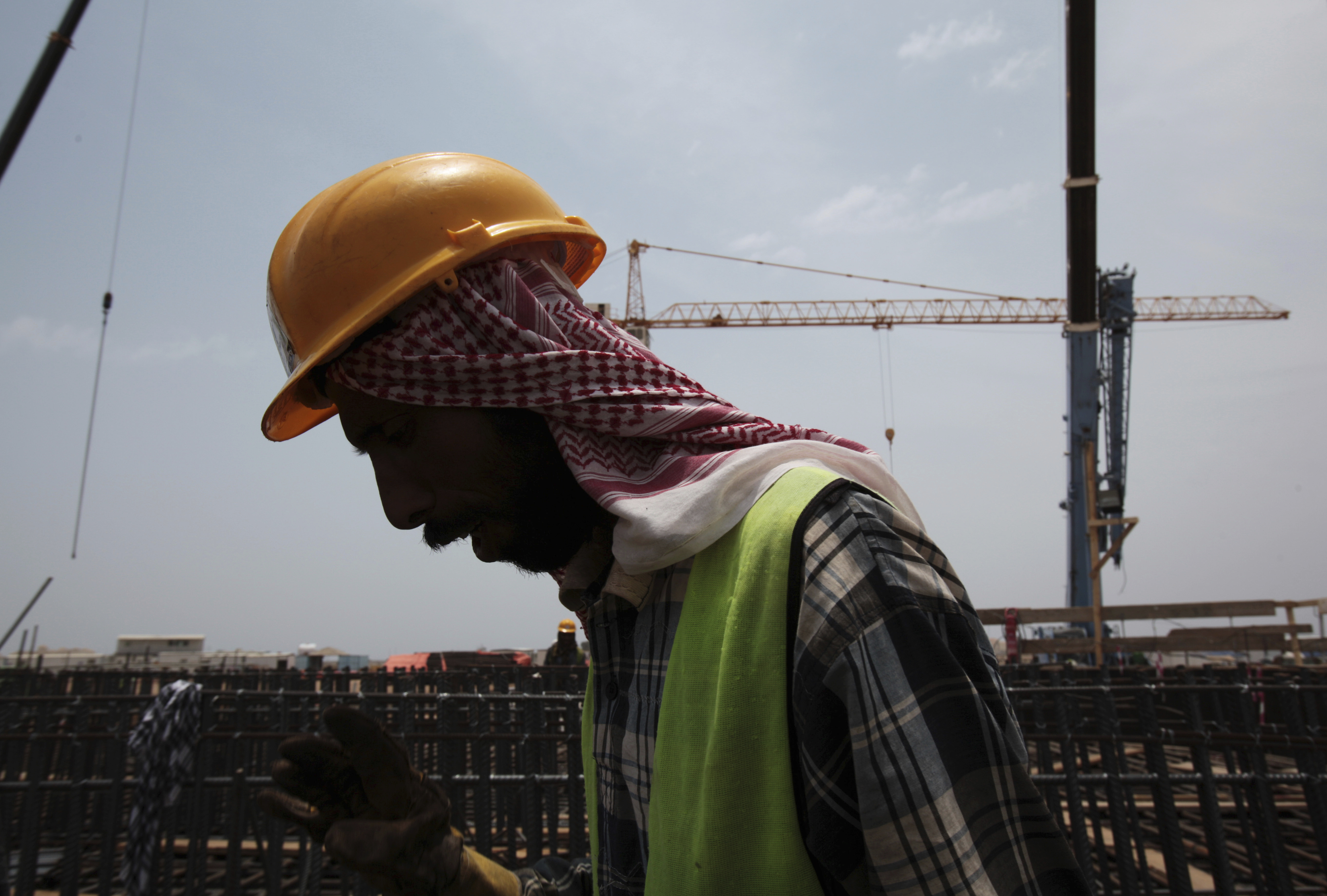 FILE - In this May 8, 2014, file photo a man works on construction of the Kingdom Tower, a planned 252-story building, which aims to become the world's tallest skyscraper when complete, in Jiddah, Saudi Arabia.(AP Photo/Hasan Jamali, File)