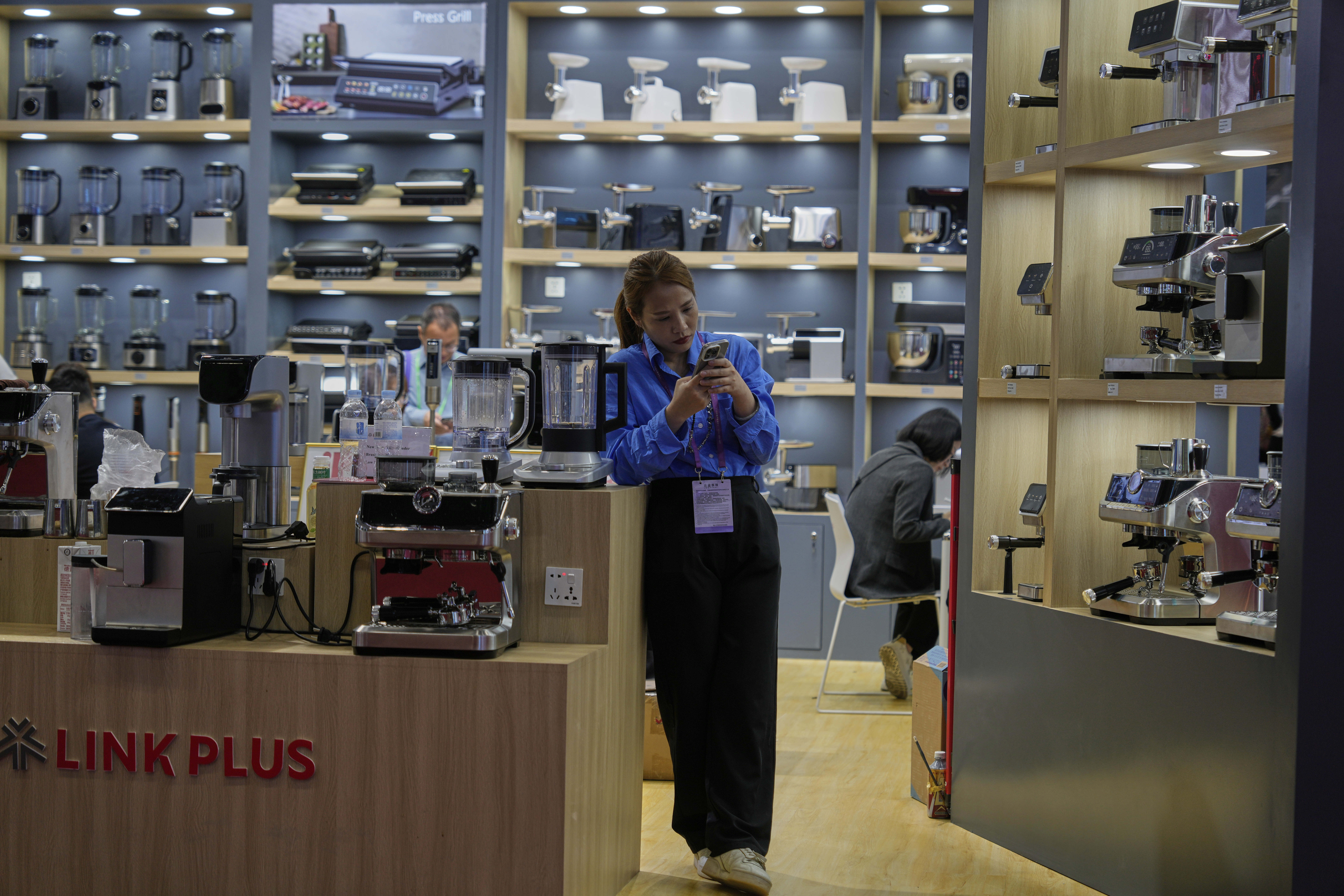 FILE - A vendor of coffee machines waits for customers at the 137th Canton Fair in Guangzhou, in southern China's Guangdong province on April 16, 2025. (AP Photo/Ng Han Guan, File)