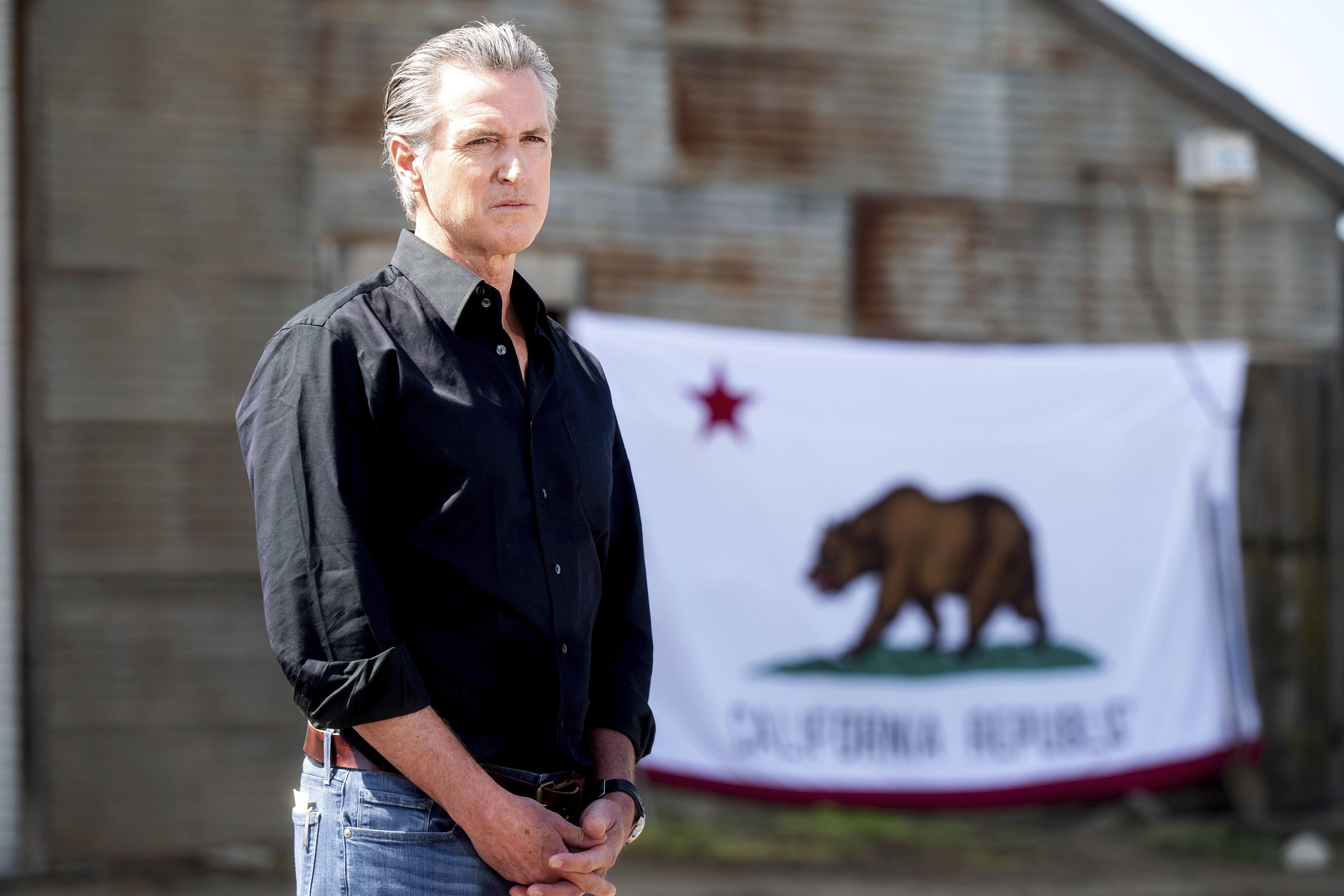 FILE - California Gov. Gavin Newsom stands in front of a state flag during a press conference about President Donald Trump's tariffs on Wednesday, April 16, 2025, at an almond farm in Ceres, Calif. (AP Photo/Noah Berger,FIle)