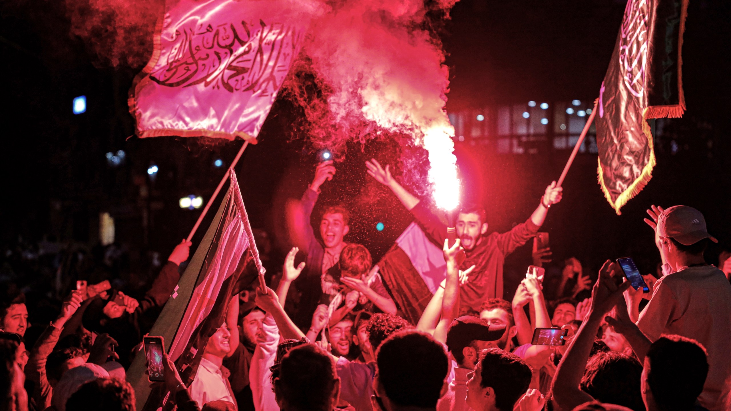 Syrians wave Saudi and Syrian flags in celebration after U.S. President Donald Trump announced plans during his visit to Saudi Arabia to ease sanctions on Syria and normalize relations with its new government, in Homs, Syria, late Tuesday, May 13, 2025.(AP Photo/Omar Albam)