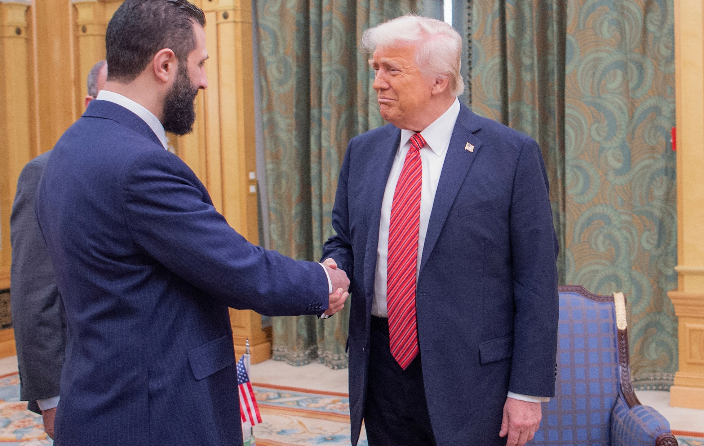 In this photo released by the Saudi Royal Palace, President Donald Trump, right, shakes hands with Syria's interim President Ahmad al-Sharaa, in Riyadh, Saudi Arabia, Wednesday, May 14, 2025. (Bandar Aljaloud/Saudi Royal Palace via AP)