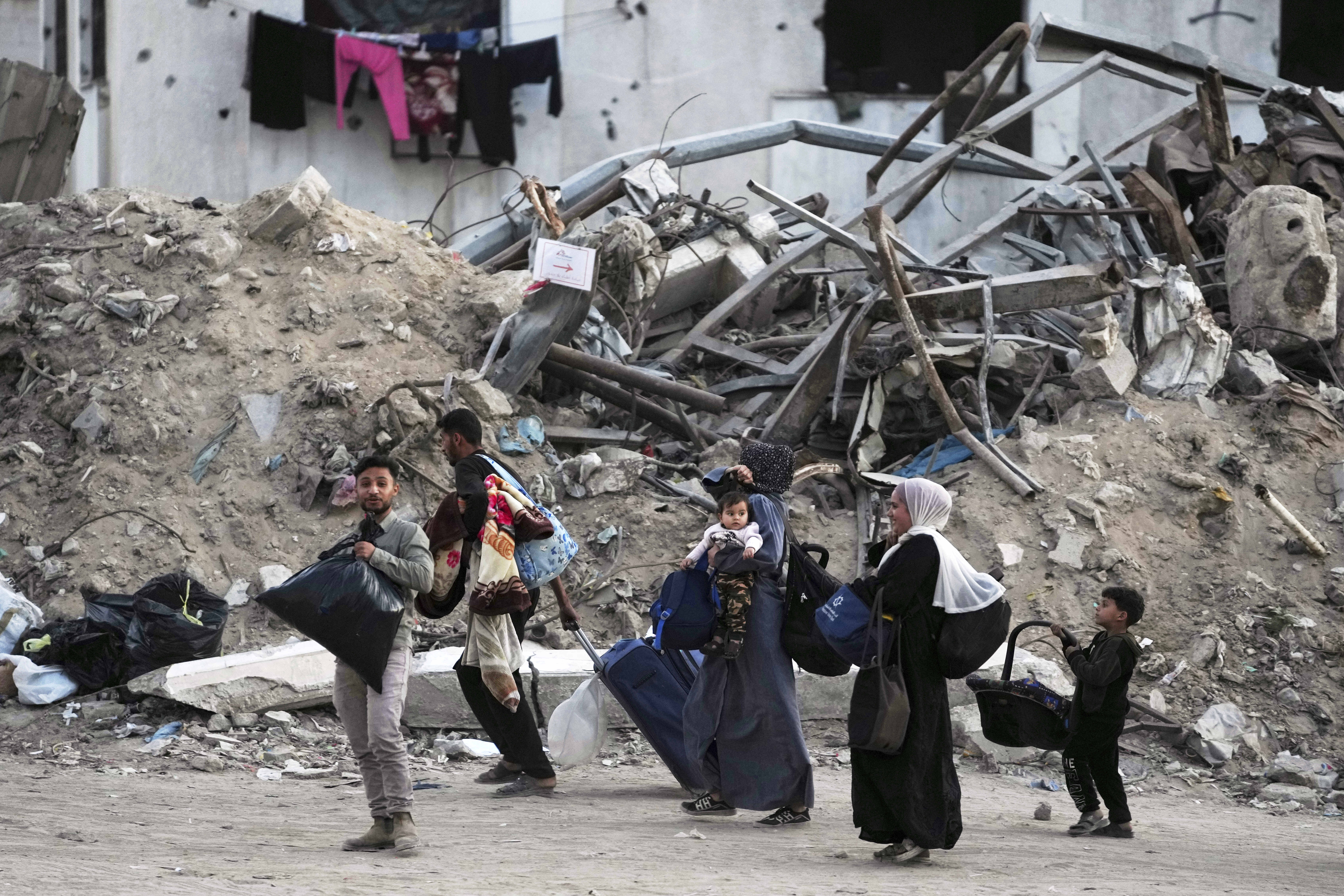 Palestinians evacuate after the Israeli army issued an evacuation warning for several schools and a hospital in Gaza City's Rimal neighborhood, Wednesday, May 14, 2025. (AP Photo/Jehad Alshrafi)