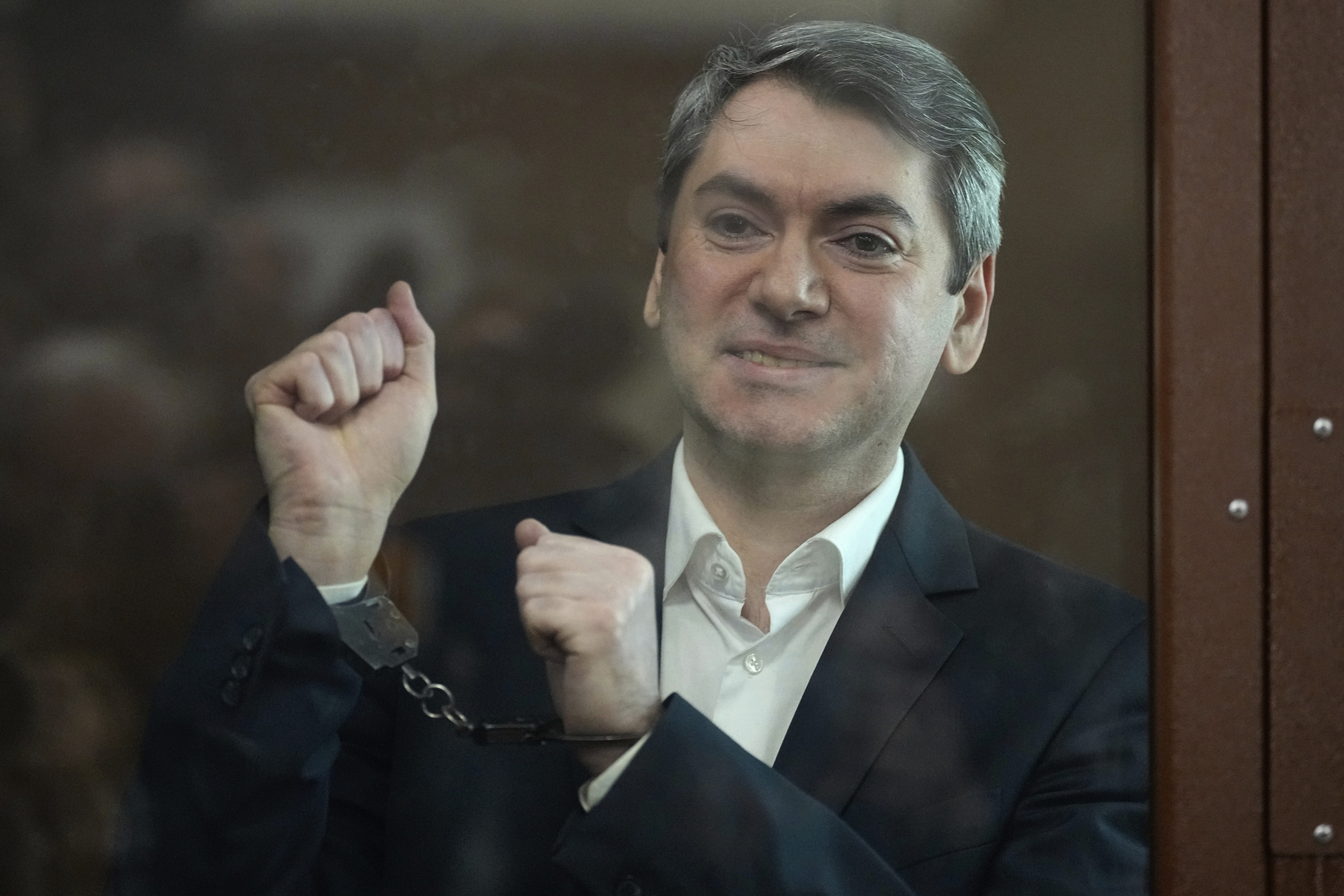 Grigory Melkonyants, co-chair of Russia's leading independent election monitoring group Golos who faces up to six years in prison, looks at the media standing in a cage in a courtroom prior to a hearing in Basmanny district court in Moscow, Russia, Wednesday, May 14, 2025. (AP Photo/Alexander Zemlianichenko)