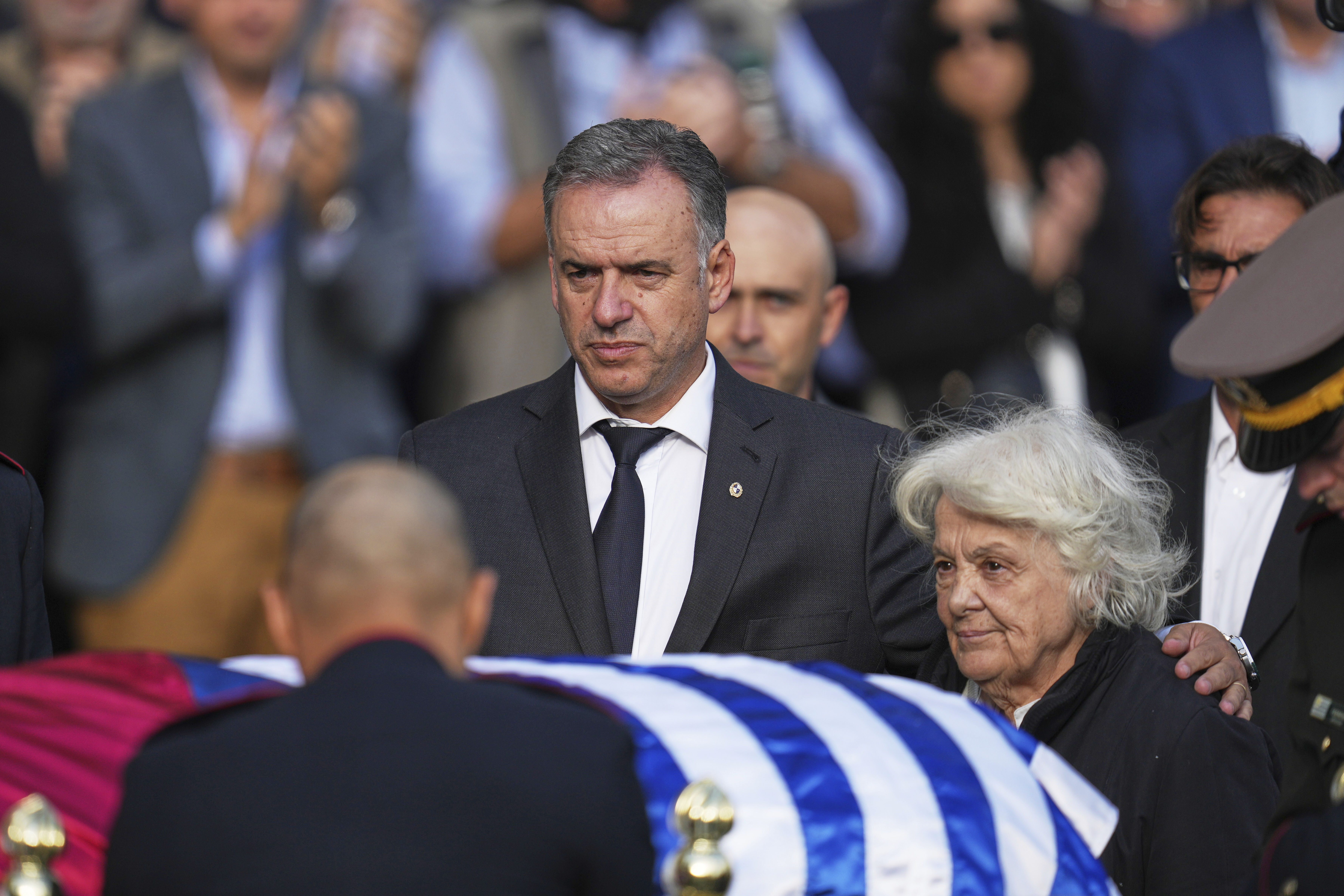 Uruguayan President Yamandu Orsi, left, stands with Lucia Topolansky, widow of the late, former President Jose Mujica, next to his casket at the presidential palace in Montevideo, Uruguay, Wednesday, May 14, 2025. (AP Photo/Matilde Campodonico)