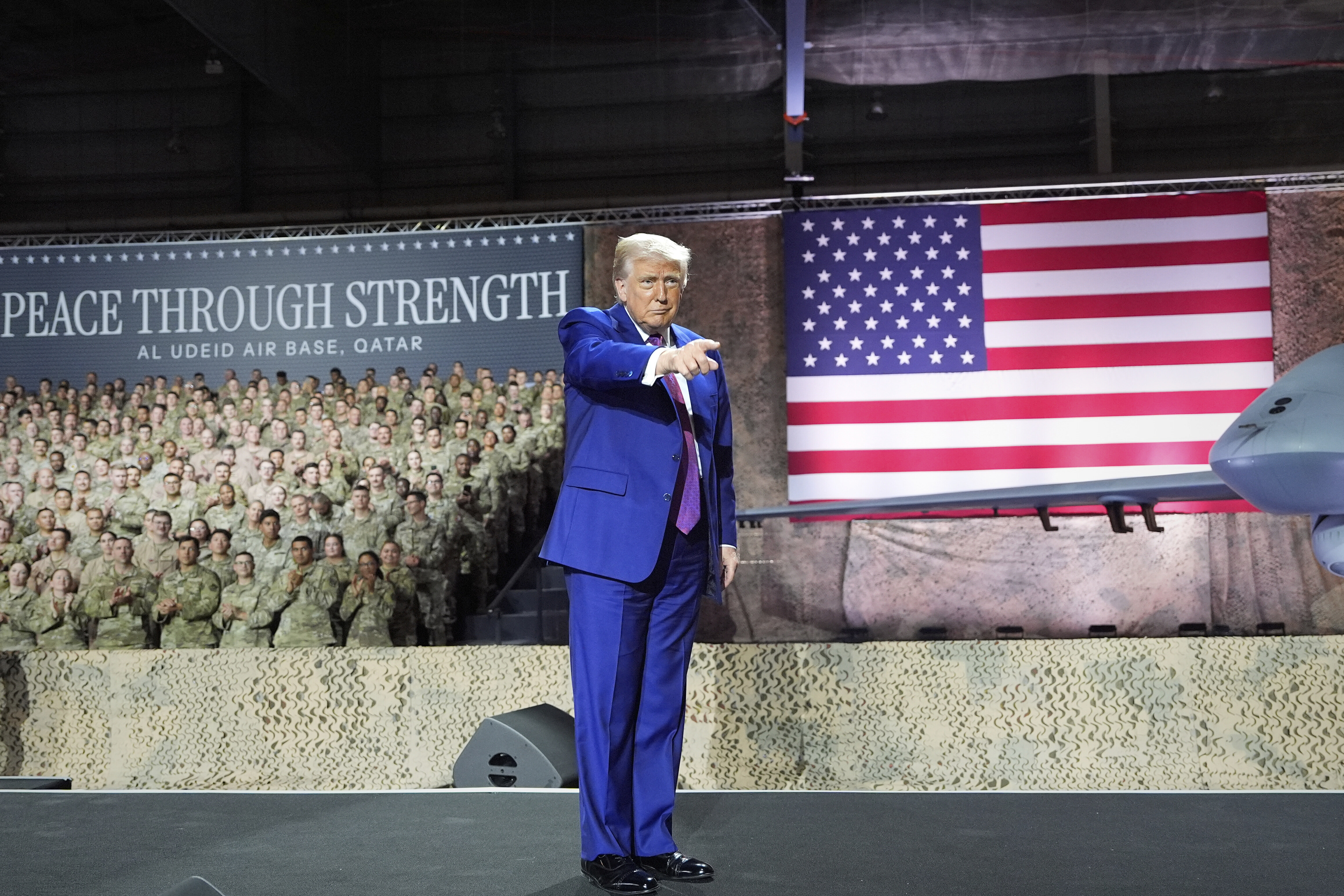 President Donald Trump gestures on stage at the Al Udeid Air Base, Thursday, May 15, 2025, in Doha, Qatar. (AP Photo/Alex Brandon)