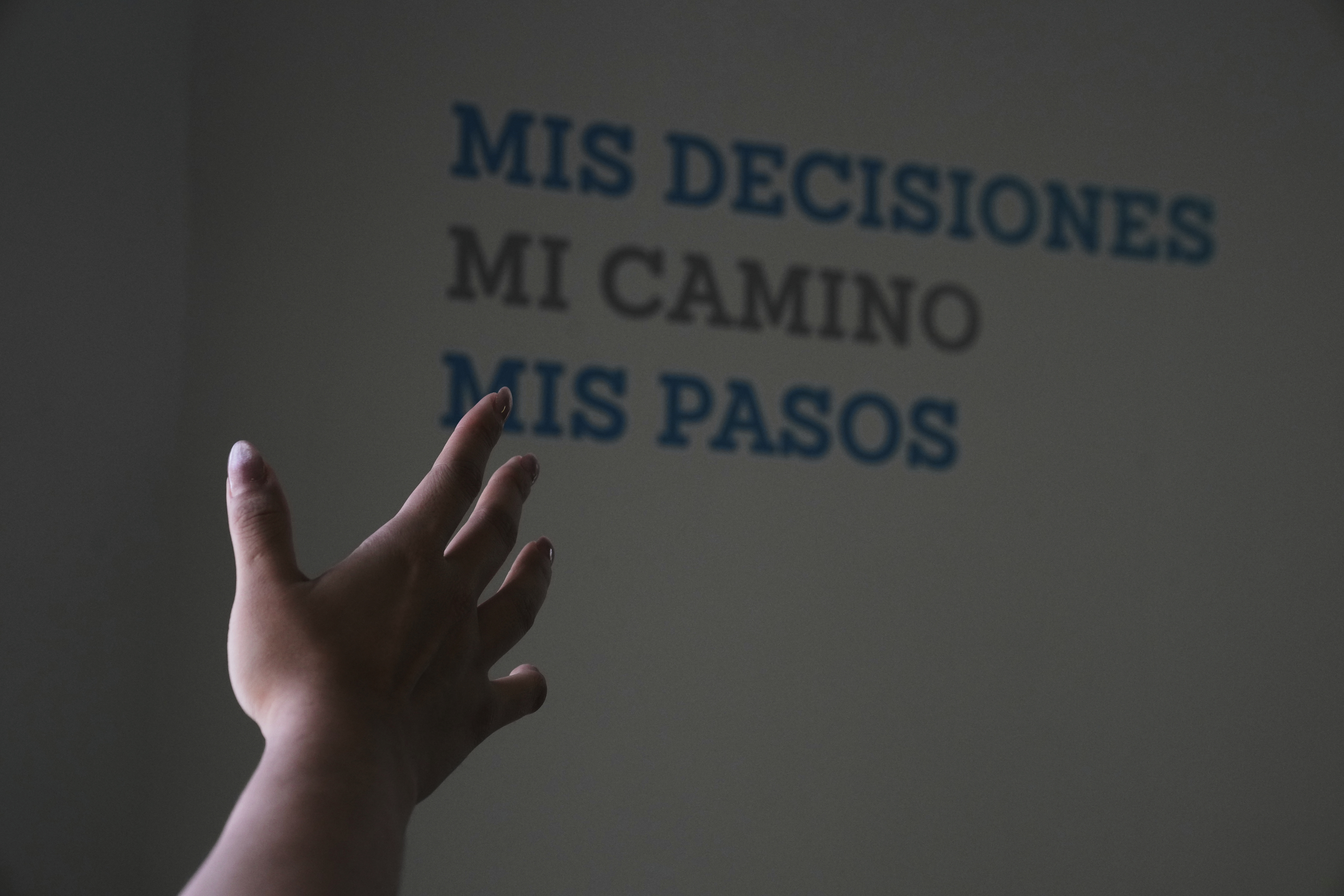 A health worker gestures towards a message that reads in Spanish; "My decisions, my road, my steps" during a tour of the MSI Foundation, an organization that offers information and help to women seeking abortions, in Mexico City, Thursday, May 8, 2025. (AP Photo/Marco Ugarte)