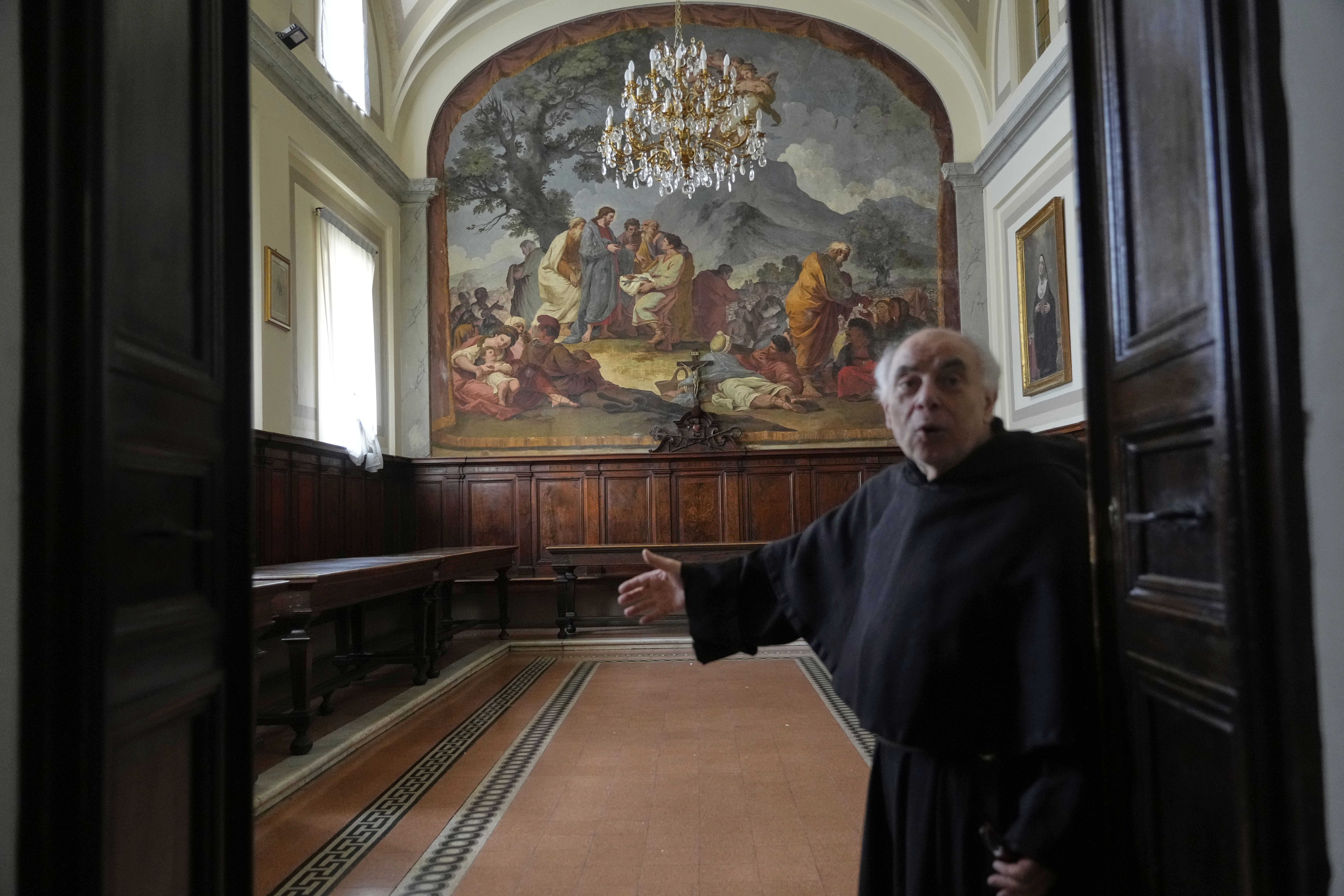 Augustinian friar Paolo Angelone shows the refectory of the Sanctuary of Our Mother of Good Counsel with a fresco by Taddeo Conza depicting the Miracle of the Loaves and Fishes, during an interview in Genazzano, Italy, Thursday, May 15, 2025. (AP Photo/Gregorio Borgia)