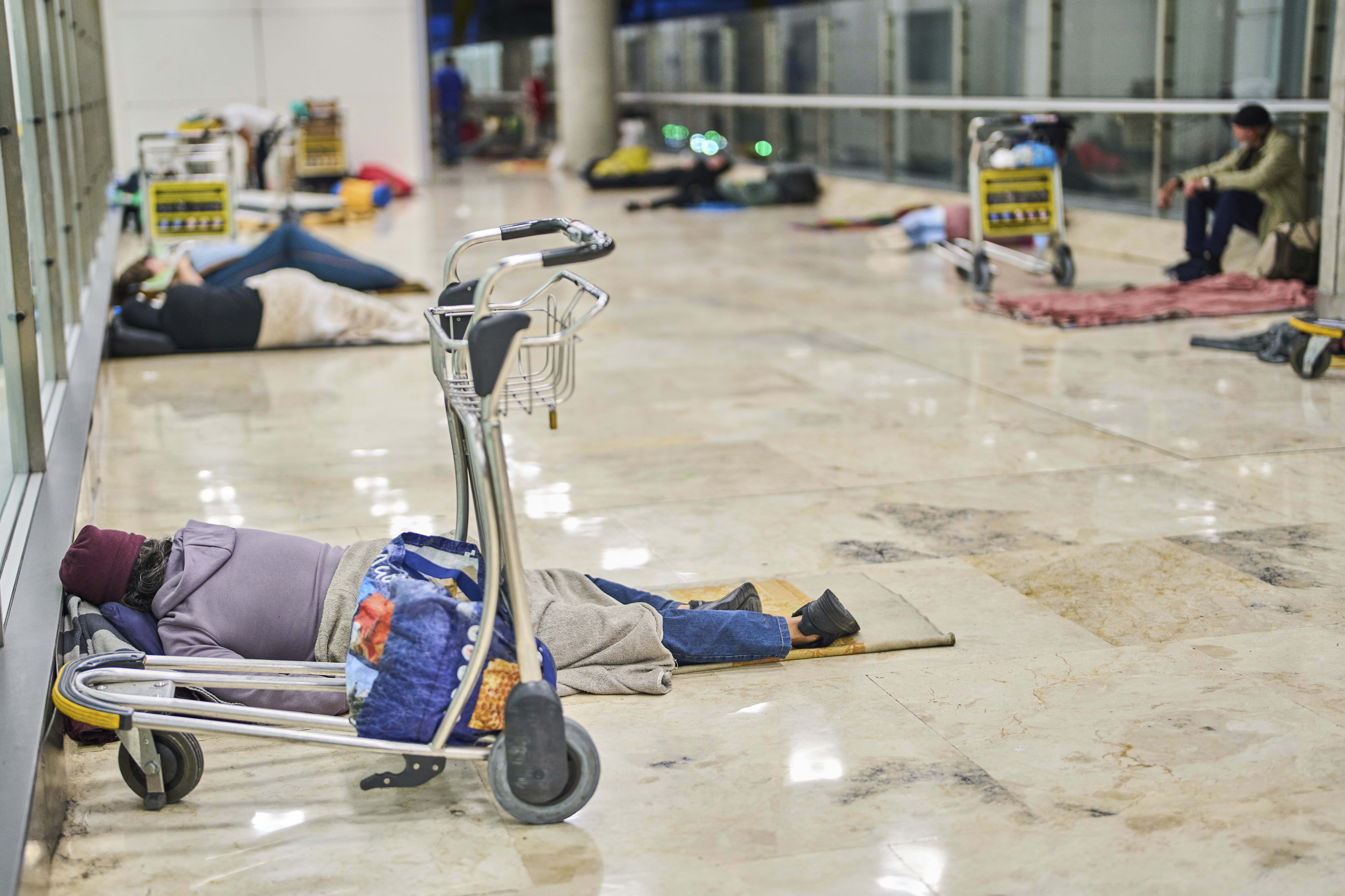 People sleep on the floor of Terminal 4 at Adolfo Suarez-Madrid Barajas Airport in Madrid, Spain, Thursday, May 15, 2025. (AP Photo/Manu Fernandez)