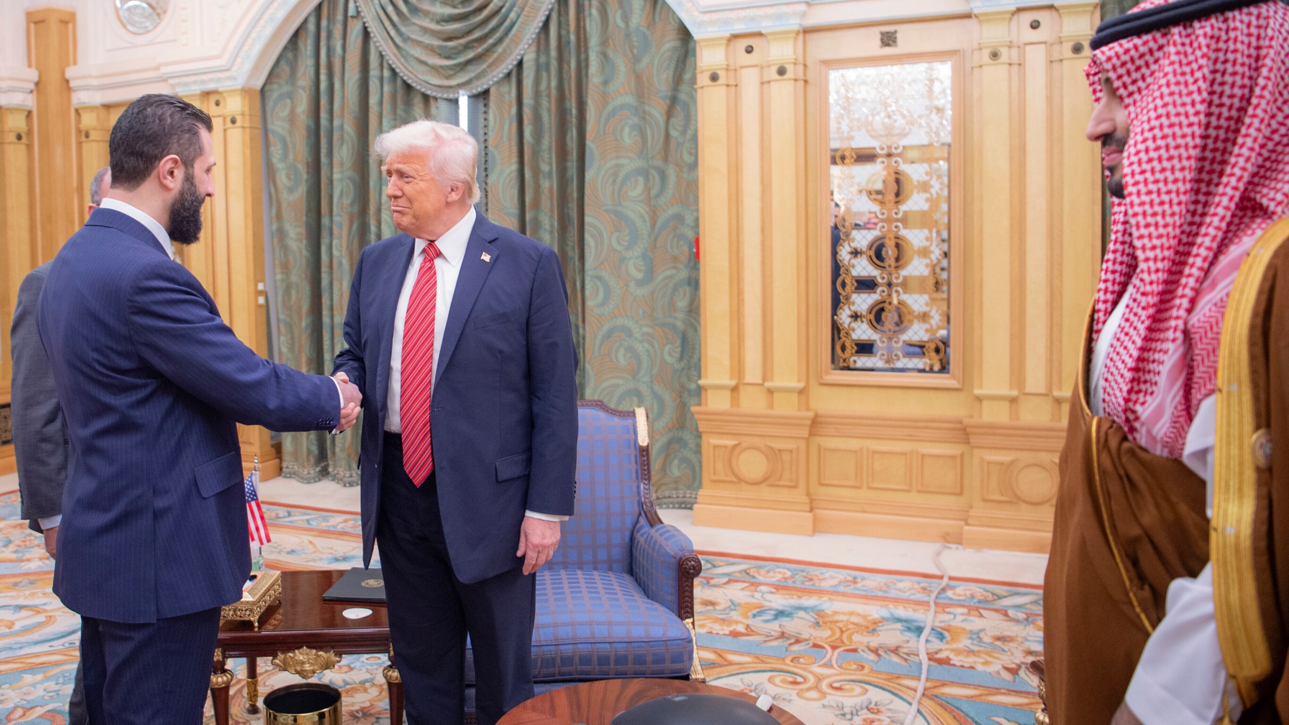 In this photo released by the Saudi Royal Palace, Syria's interim President Ahmad al-Sharaa, left, shakes hands with President Donald Trump, centre, in Riyadh, Saudi Arabia, Wednesday, May 14, 2025. At right is Saudi Crown Prince Mohammed bin Salman.(Bandar Aljaloud/Saudi Royal Palace via AP)