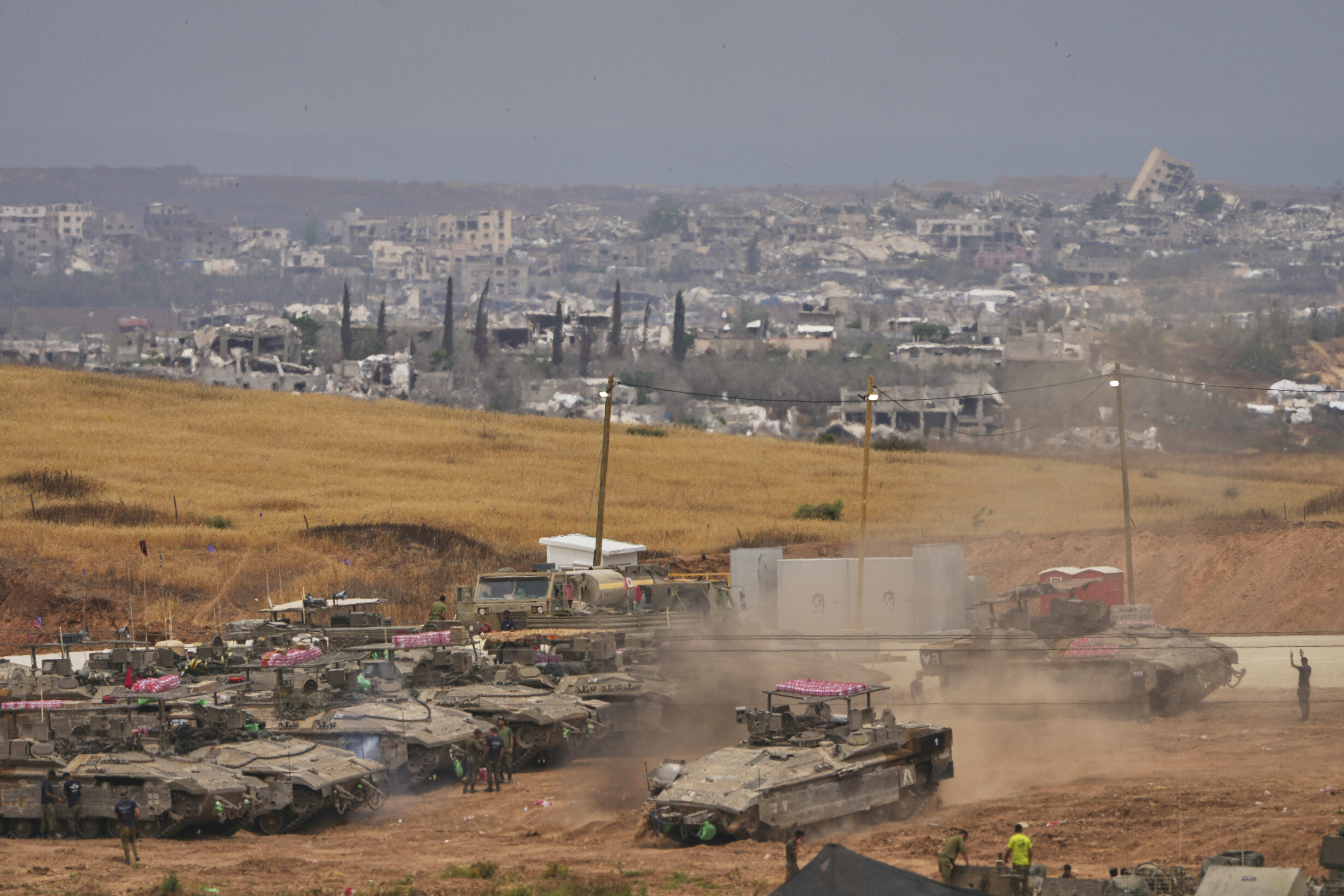 Israeli soldiers work on tanks and APCs at a staging area near the border with the Gaza Strip, in southern Israel, Thursday, May 15, 2025. (AP Photo/Ariel Schalit)