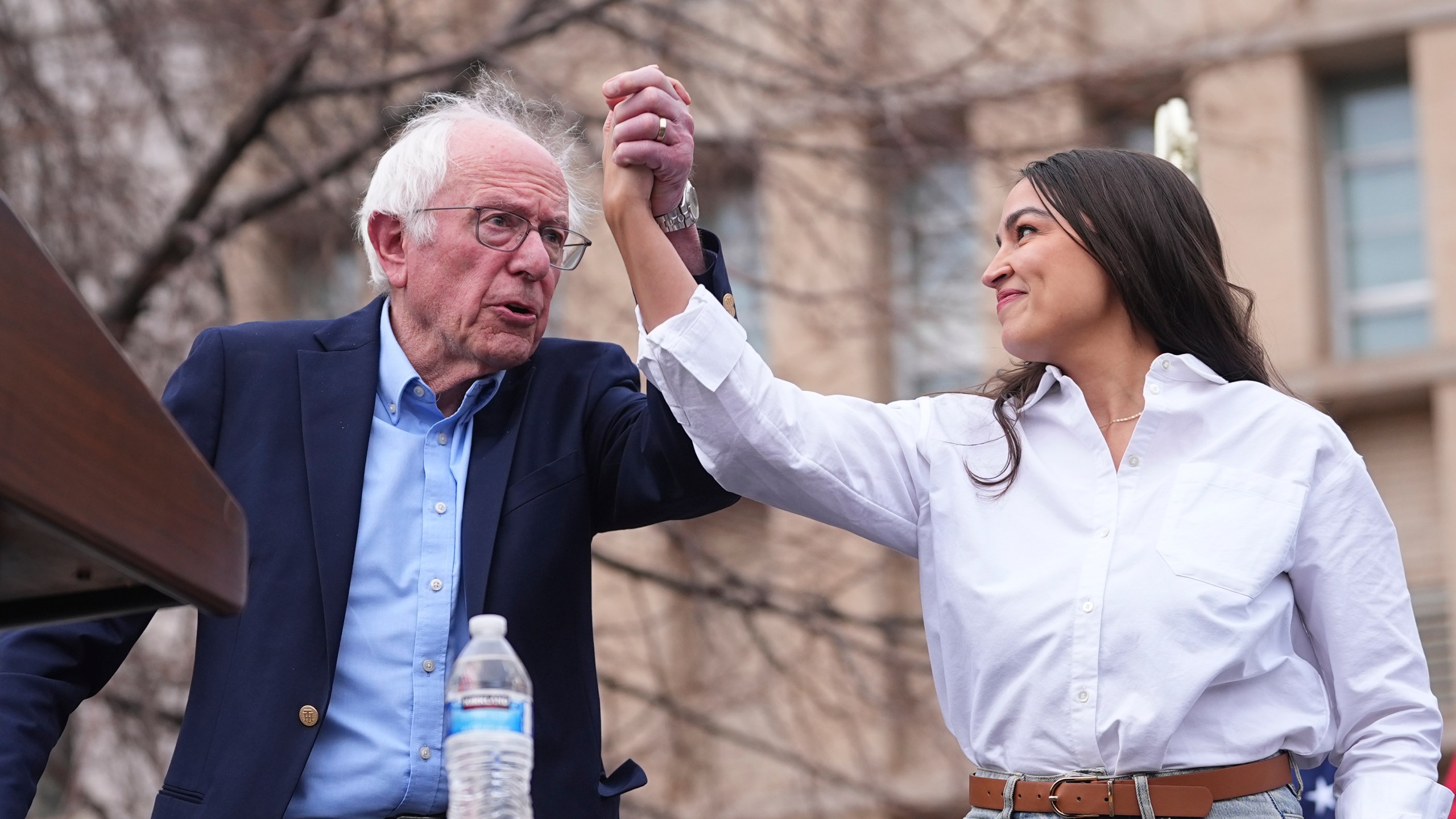 FILE _ Sen. Bernie Sanders, I-Vt., left, greets Rep. Alexandria Ocasio-Cortez, D-N.Y., as they speak during a stop of their "Fighting Oligarchy" tour at Civic Center Park, March 21, 2025, in Denver. (AP Photo/David Zalubowski, File)
