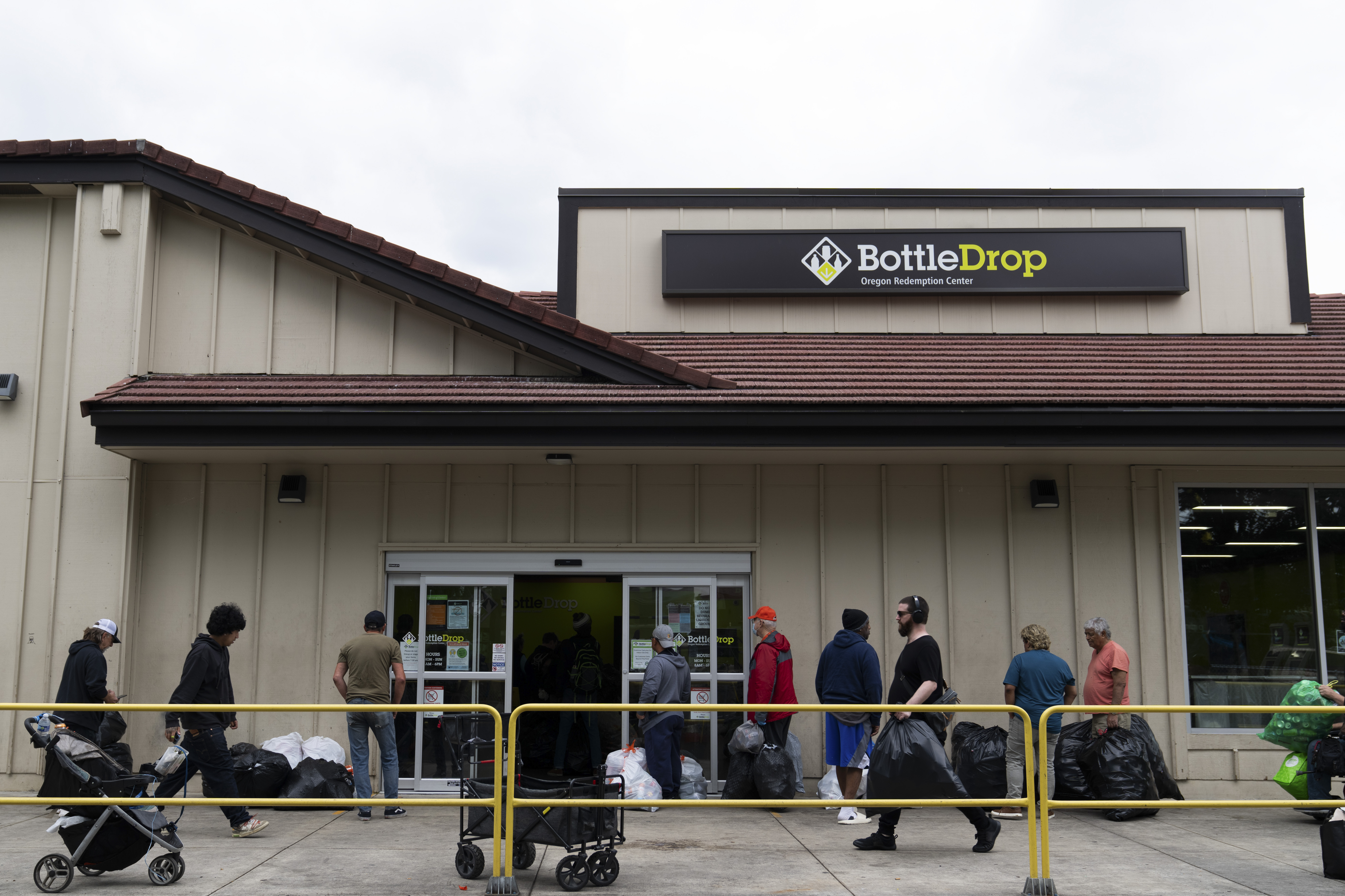People wait in line outside the Glisan BottleDrop Redemption Center on Thursday, May 15, 2025, in Portland, Ore. (AP Photo/Jenny Kane)