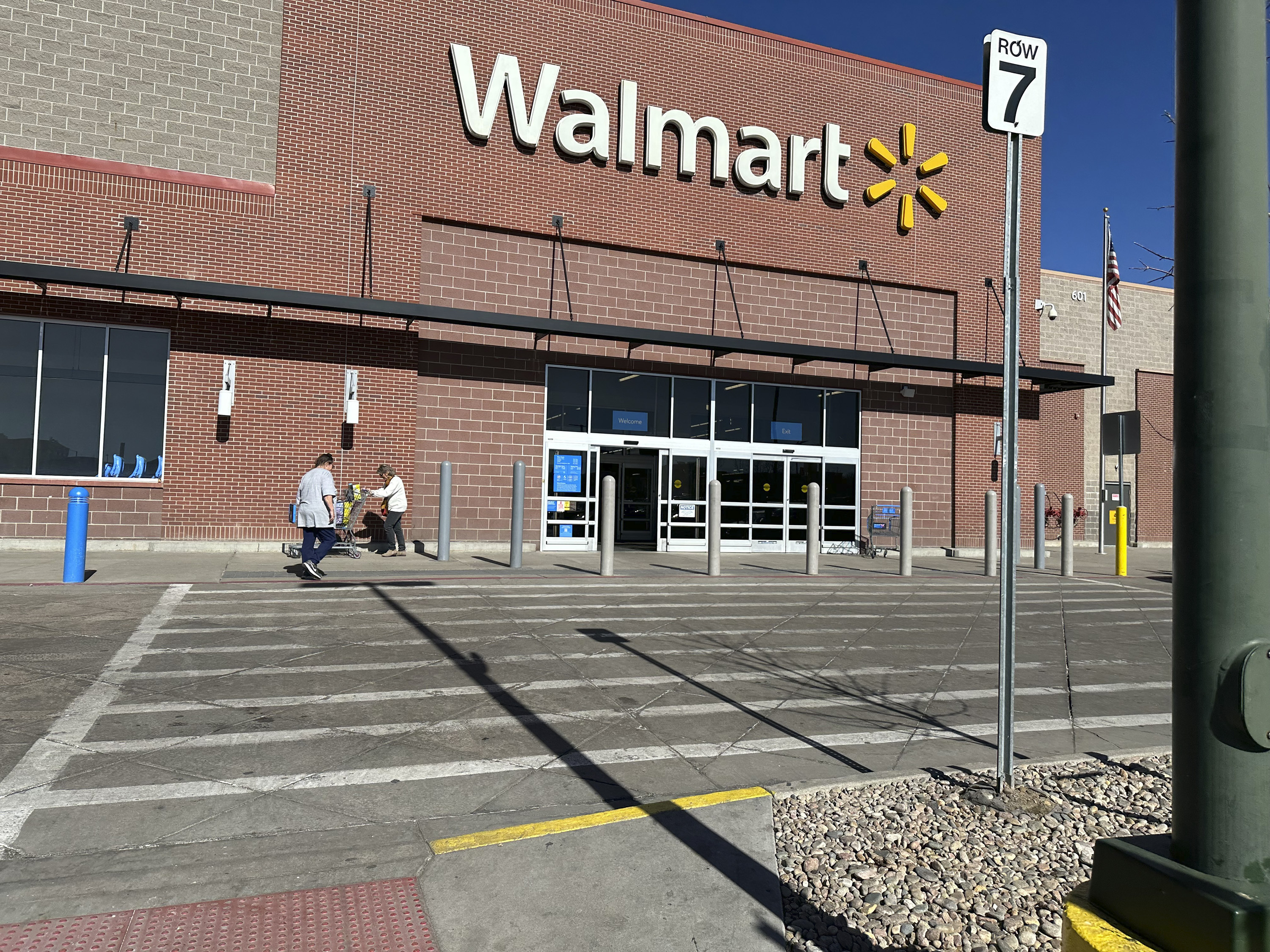 FILE -Shoppers outside a Walmart store, Feb. 7, 2025, in Englewood, Colo. (AP Photo/David Zalubowski), File)
