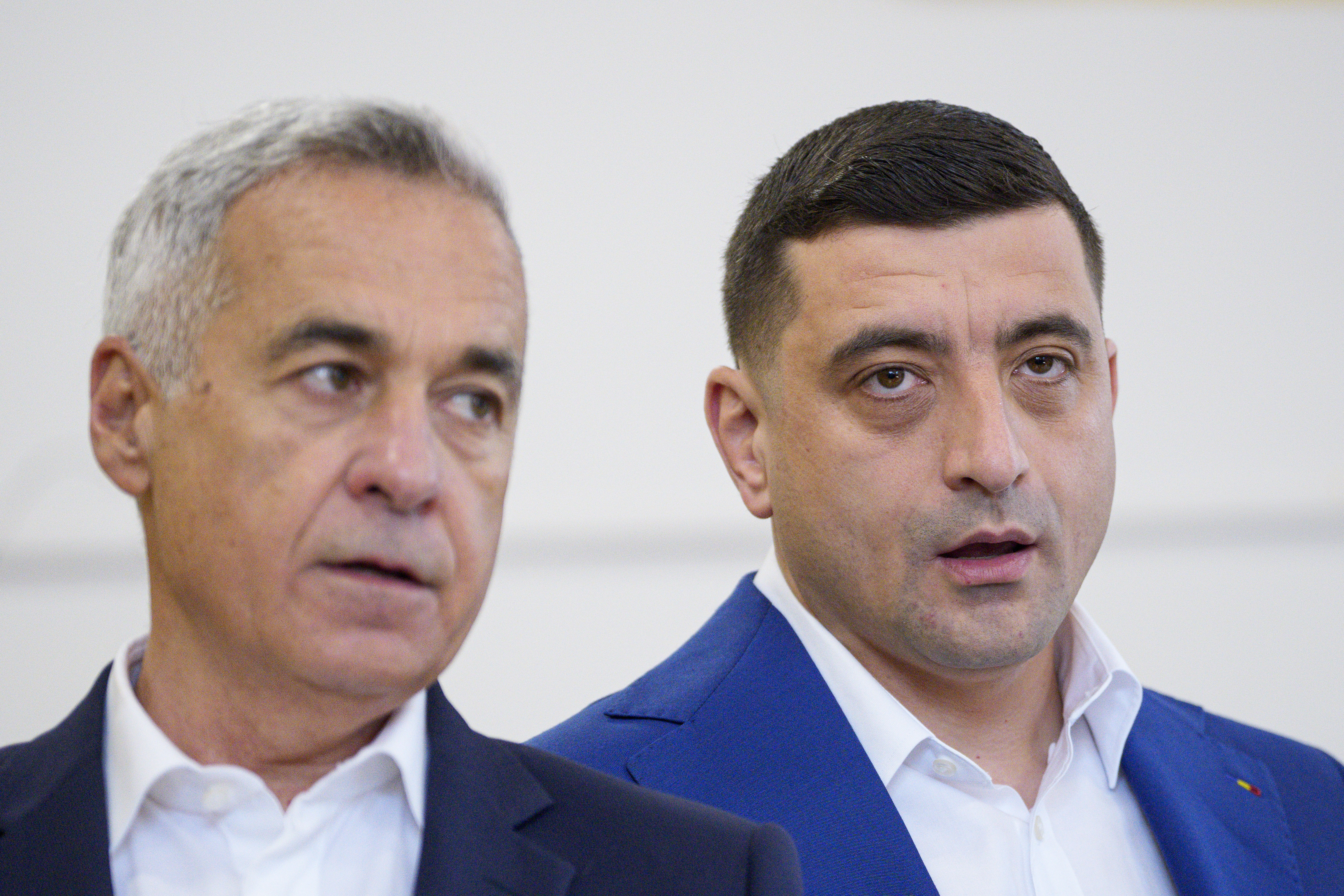 Presidential candidate George Simion, right, and Calin Georgescu, winner of the first round of last year's annulled election, speak to the media after casting their votes in the second round of the country's presidential election redo in Mogosoaia, Romania, Sunday, May 18, 2025. (AP Photo/Andreea Alexandru)