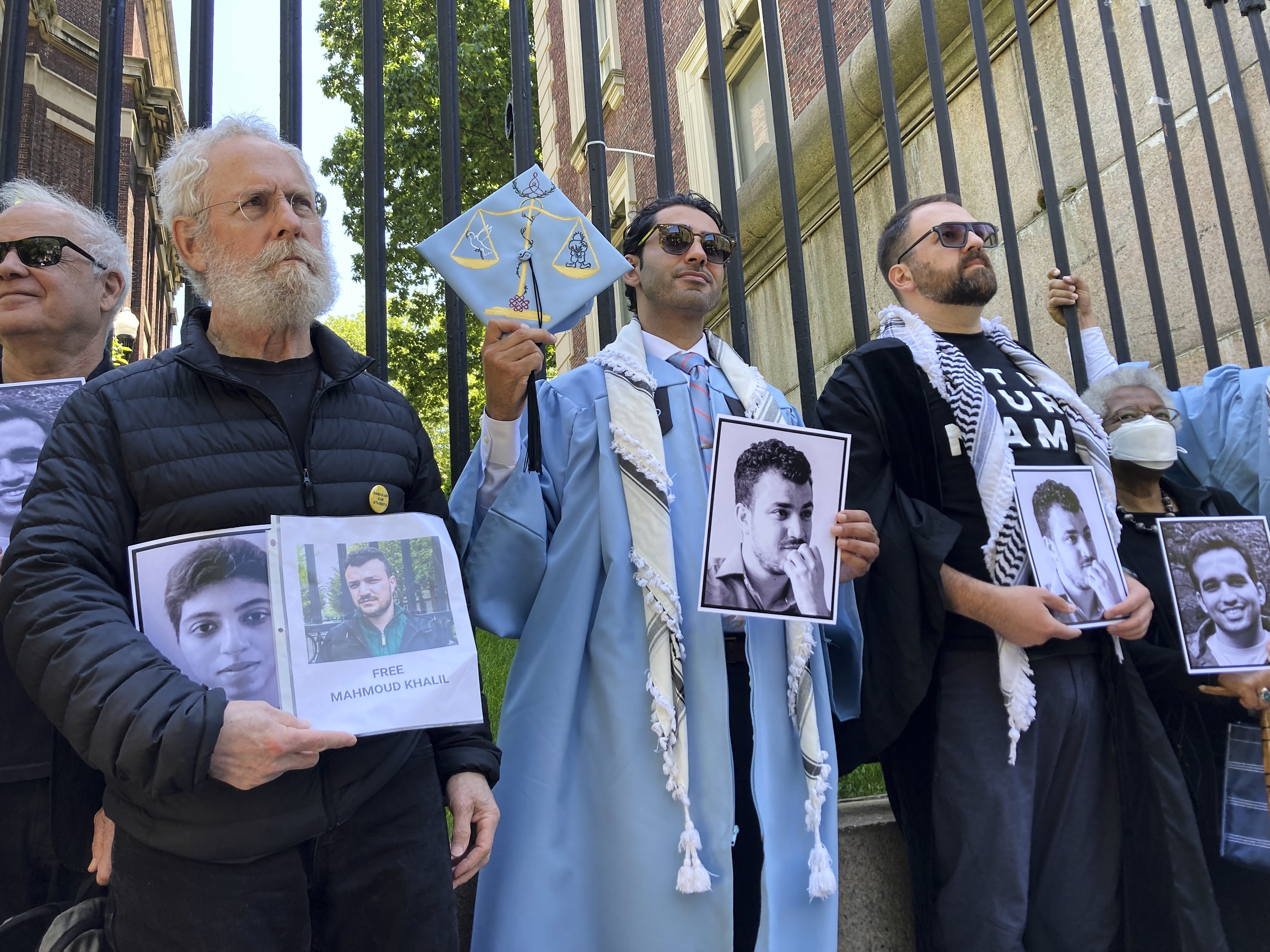 Mohsen Mahdawi, center, holds a photo of Mahmoud Khalil while posing for a photo with demonstrators outside the gates of Columbia University after graduating, Monday, May 19, 2025, in New York. (AP Photo/Jake Offenhartz)
