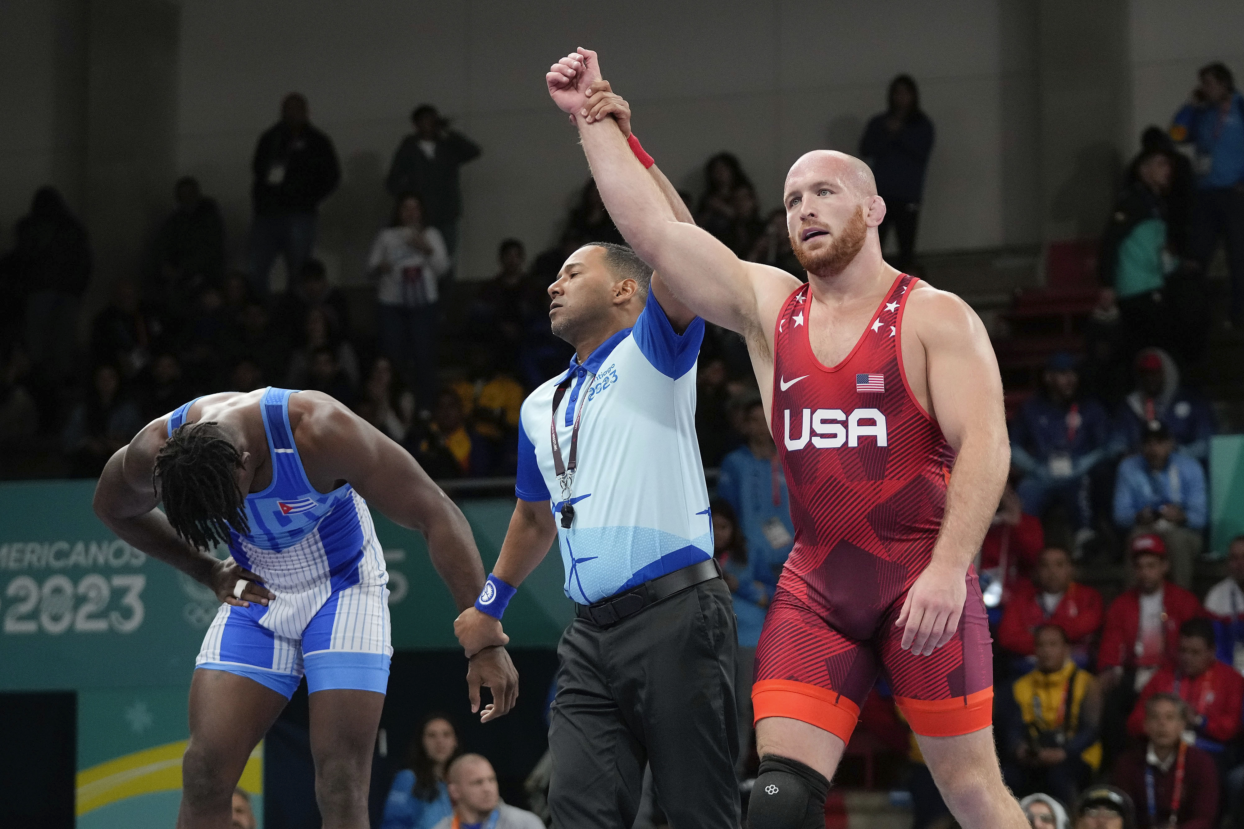 FILE - United States' Kyle Snyder, right, celebrates after winning gold against Cuba's Arturo Silot, left, during the men's 97kg wrestling freestyle final bout at the Pan American Games Santiago, Chile, Nov. 1, 2023. (AP Photo/Matias Delacroix, File)
