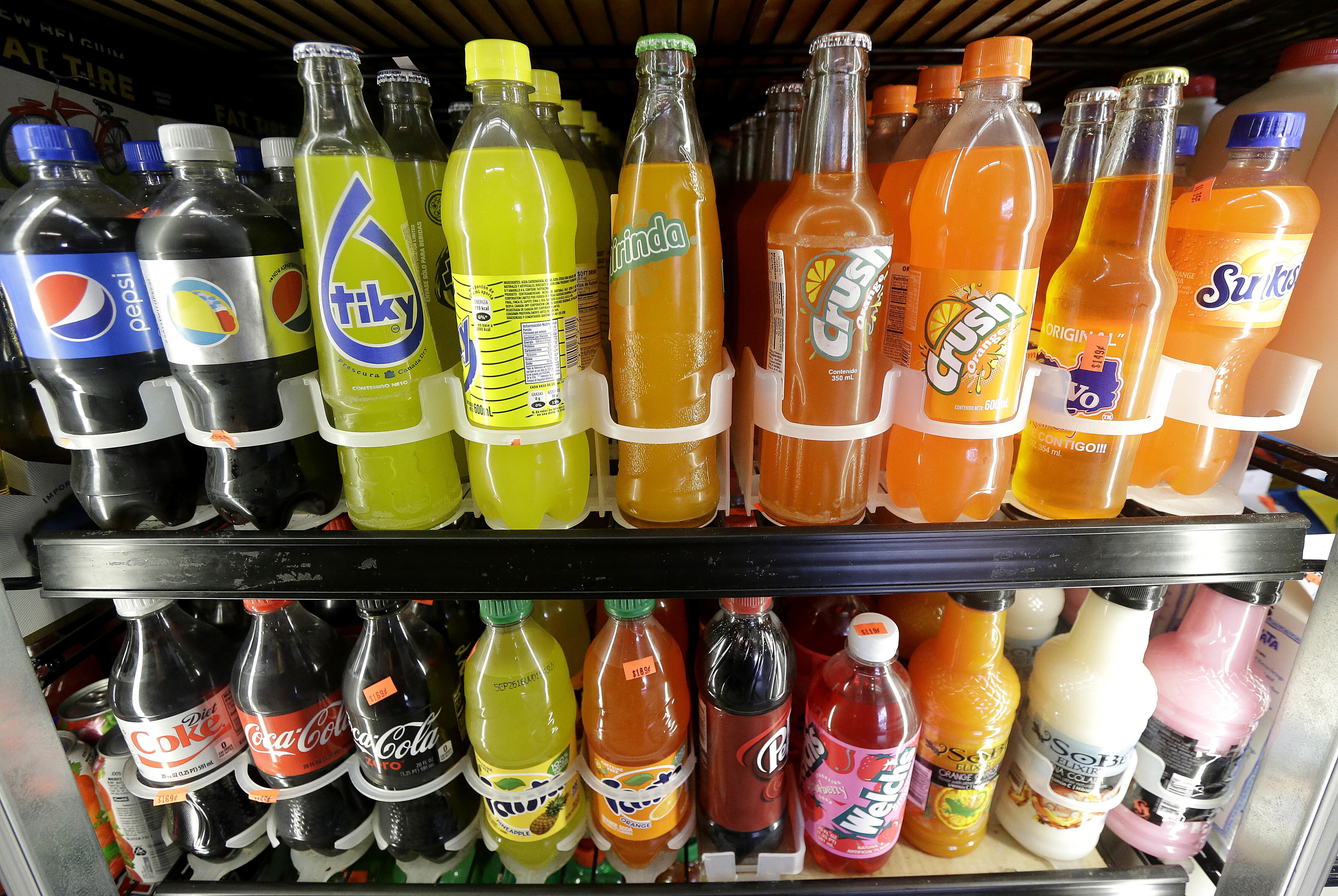 FILE - Soft drink and soda bottles are on display in a refrigerator at El Ahorro market in San Francisco, Sept. 21, 2016. (AP Photo/Jeff Chiu, File)