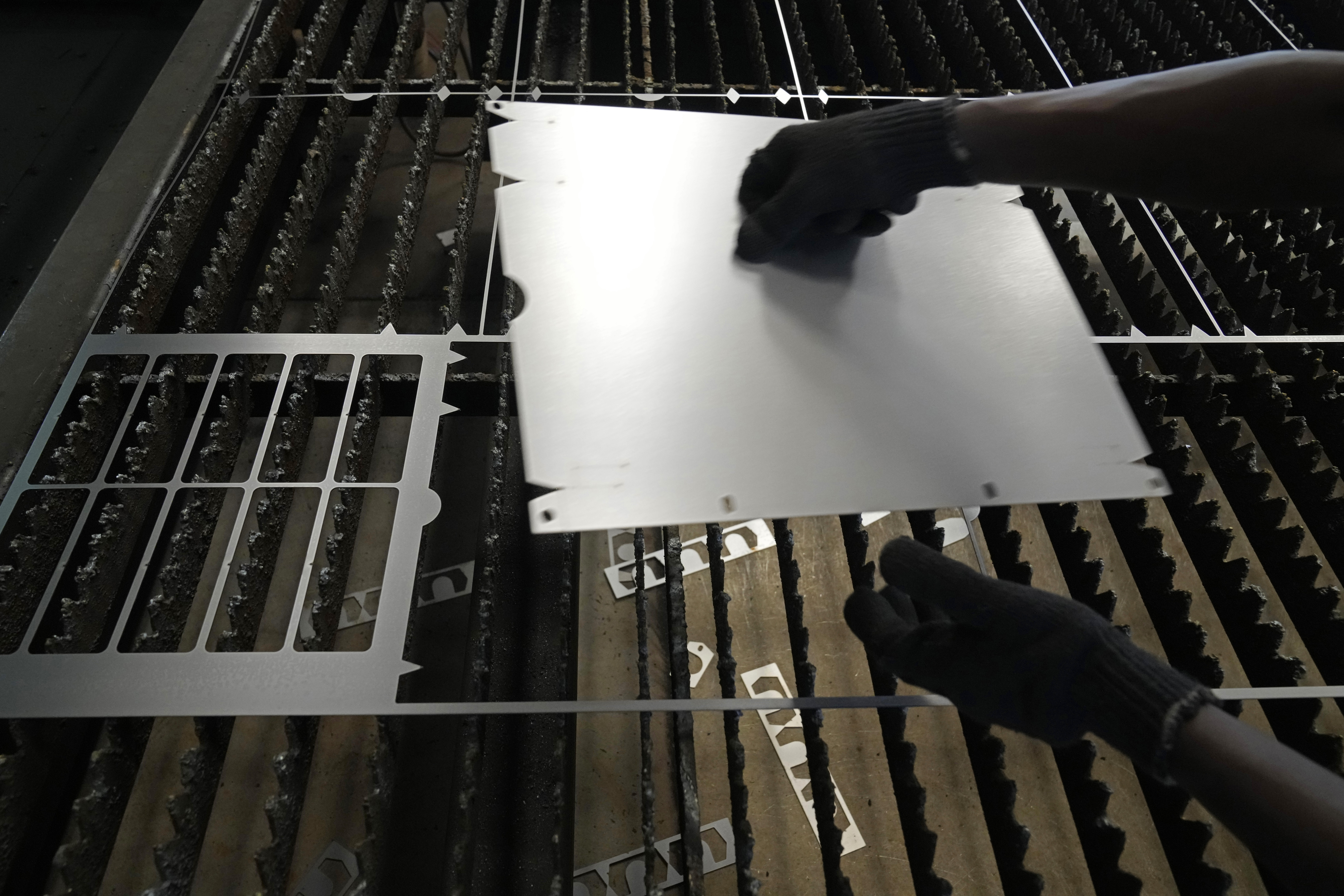 FILE - A worker lifts a steel sheet after cutting it in a specific design at a factory in a suburb of Bengaluru, India, Feb. 27, 2025. (AP Photo/Aijaz Rahi, File)