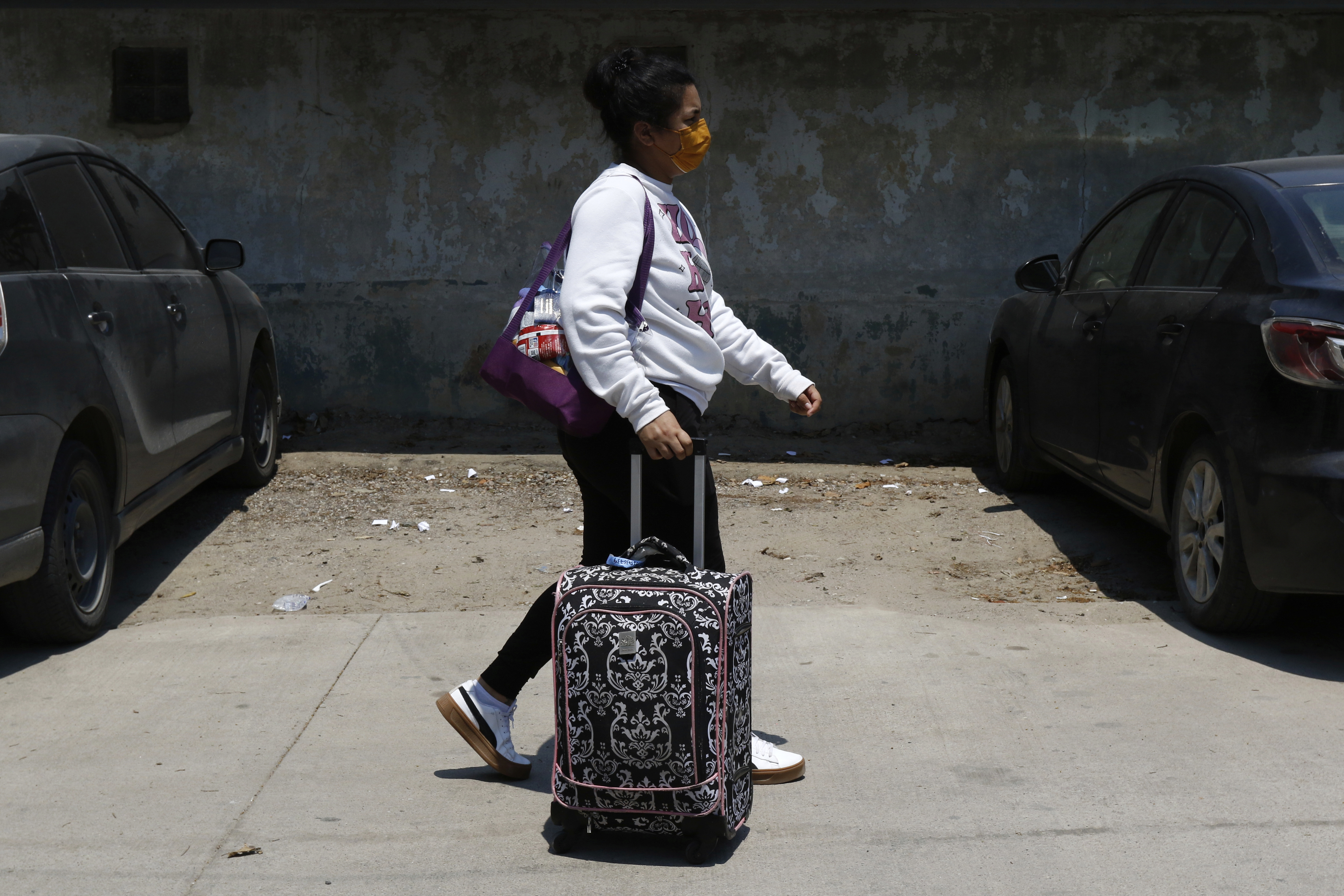 A Honduran migrant who returned voluntarily from the United States walks after arriving at Ramon Villeda Morales Airport in San Pedro Sula, Honduras, Monday, May 19, 2025. (AP Photo/Delmer Martinez)