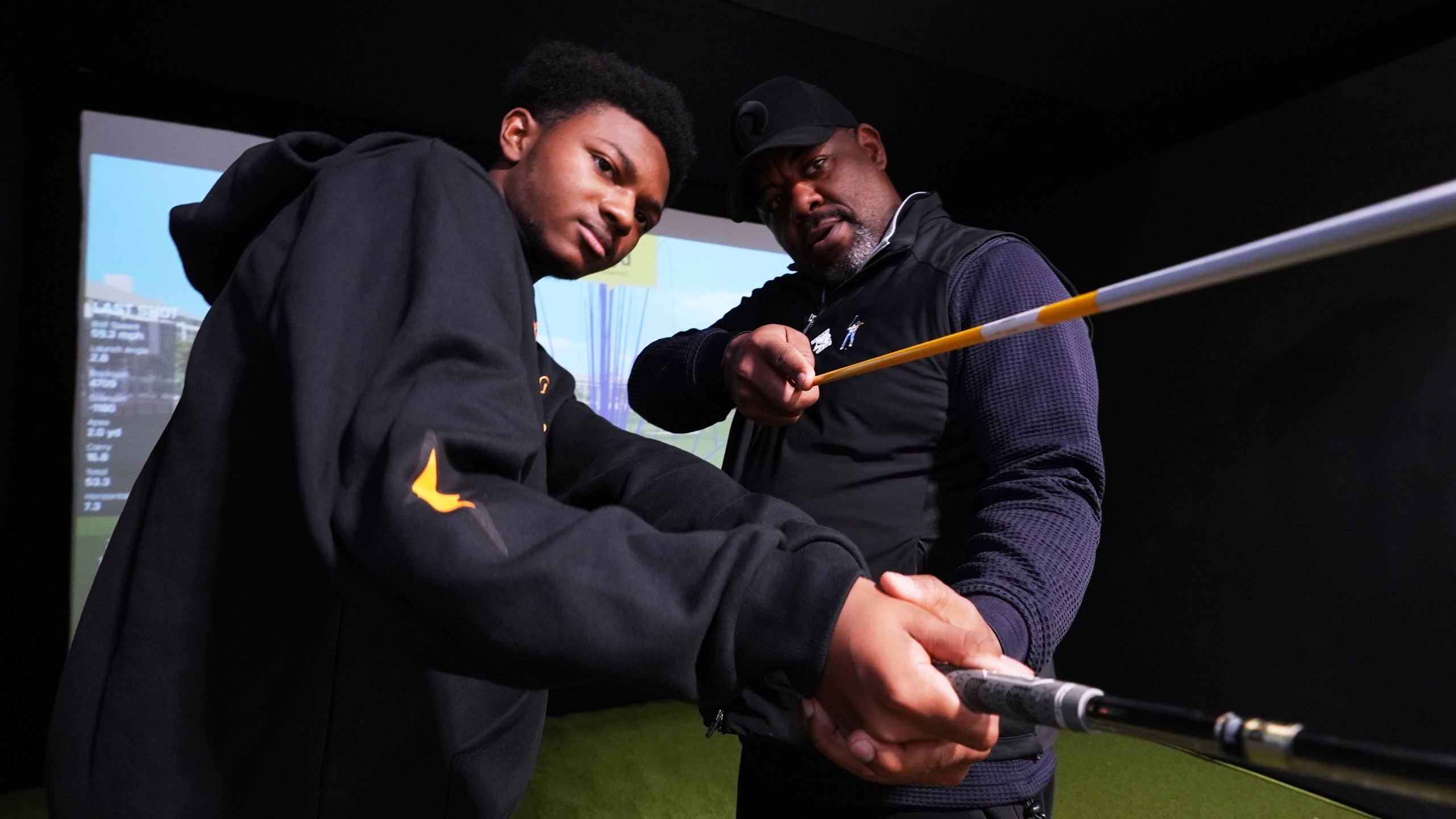 Shaun Horne, 16, a junior at Renaissance High School works on his swing with golf coach Jess Hawkins in Detroit, Thursday, Feb. 27, 2025. (AP Photo/Paul Sancya)