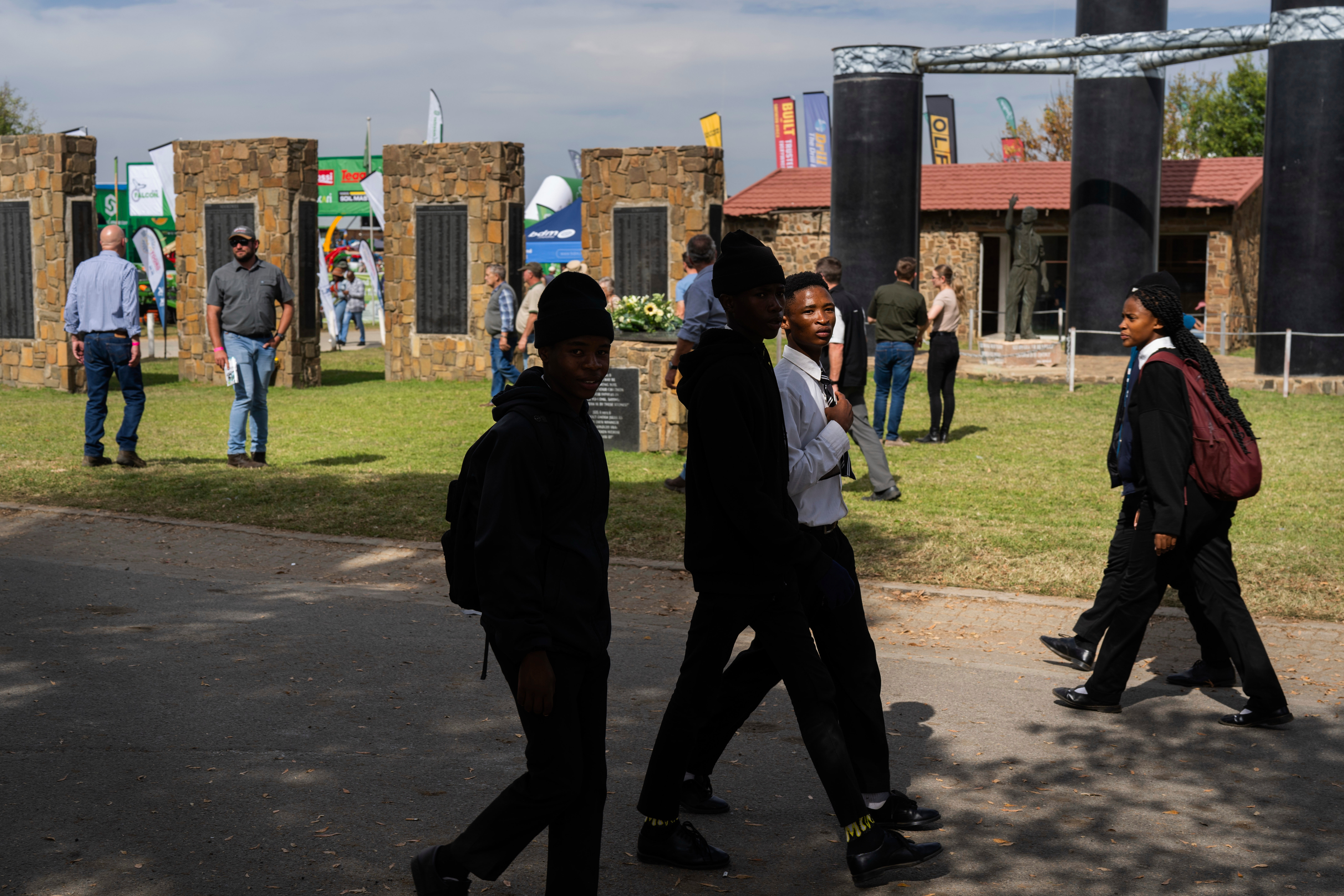Visitors at the Nampo agricultural fair, one of the largest in the southern hemisphere, walk past the wall of remembrance, a tribute to farmers killed since 1961, near Bothaville, South Africa, May 15, 2025. (AP Photo/Jerome Delay)