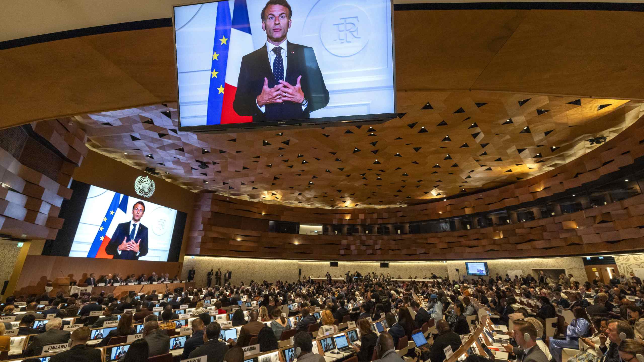 French President, Emmanuel Macron, delivers a statement on a video about the historic agreement on how to combat future pandemics, aimed at avoiding a repeat of the mistakes made during the Covid-19 crisis, during the 78th World Health Assembly (WHA78) at the European headquarters of the United Nations in Geneva, Switzerland, Tuesday, May 20, 2025. (Magali Girardin/Keystone via AP)