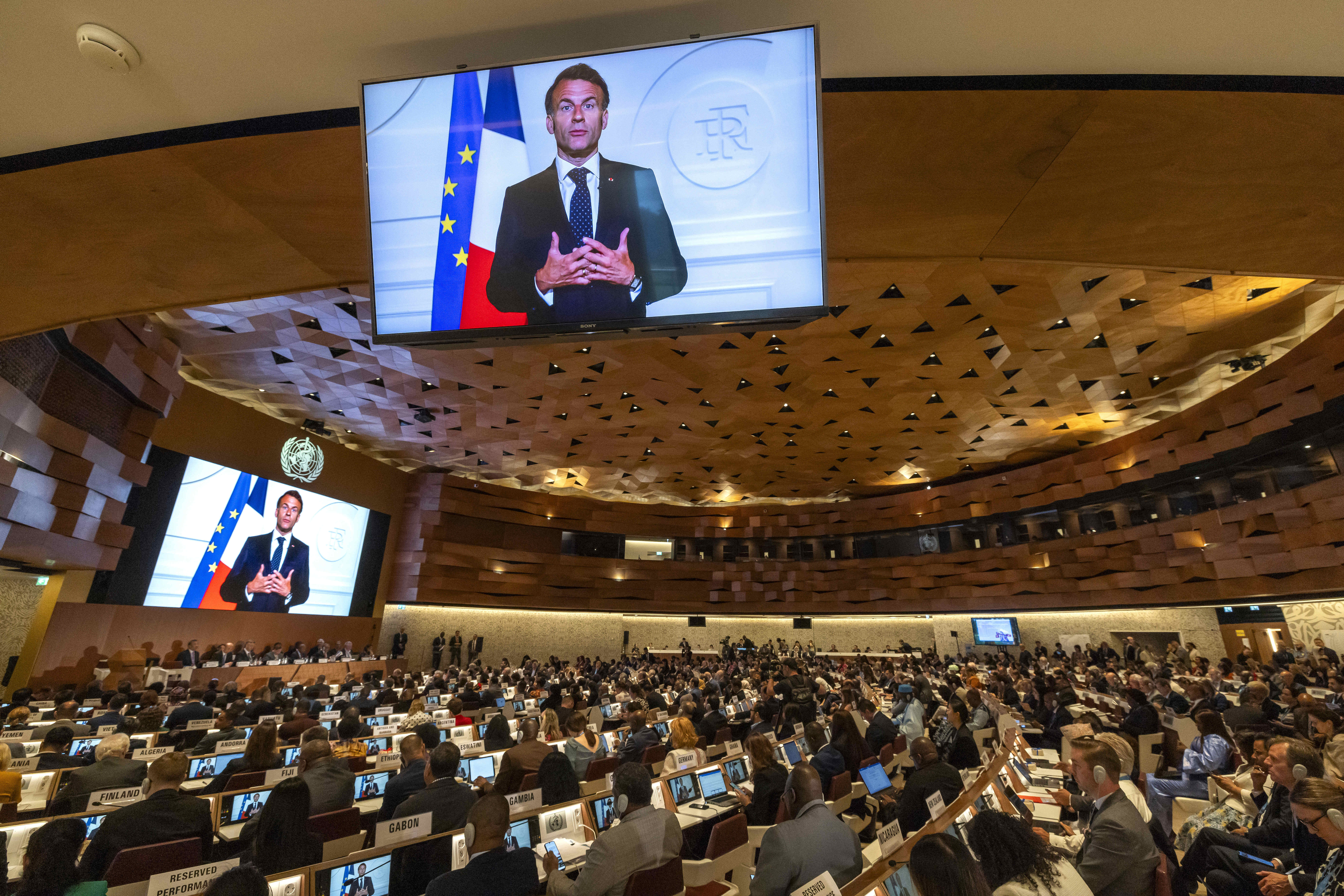 French President, Emmanuel Macron, delivers a statement on a video about the historic agreement on how to combat future pandemics, aimed at avoiding a repeat of the mistakes made during the Covid-19 crisis, during the 78th World Health Assembly (WHA78) at the European headquarters of the United Nations in Geneva, Switzerland, Tuesday, May 20, 2025. (Magali Girardin/Keystone via AP)