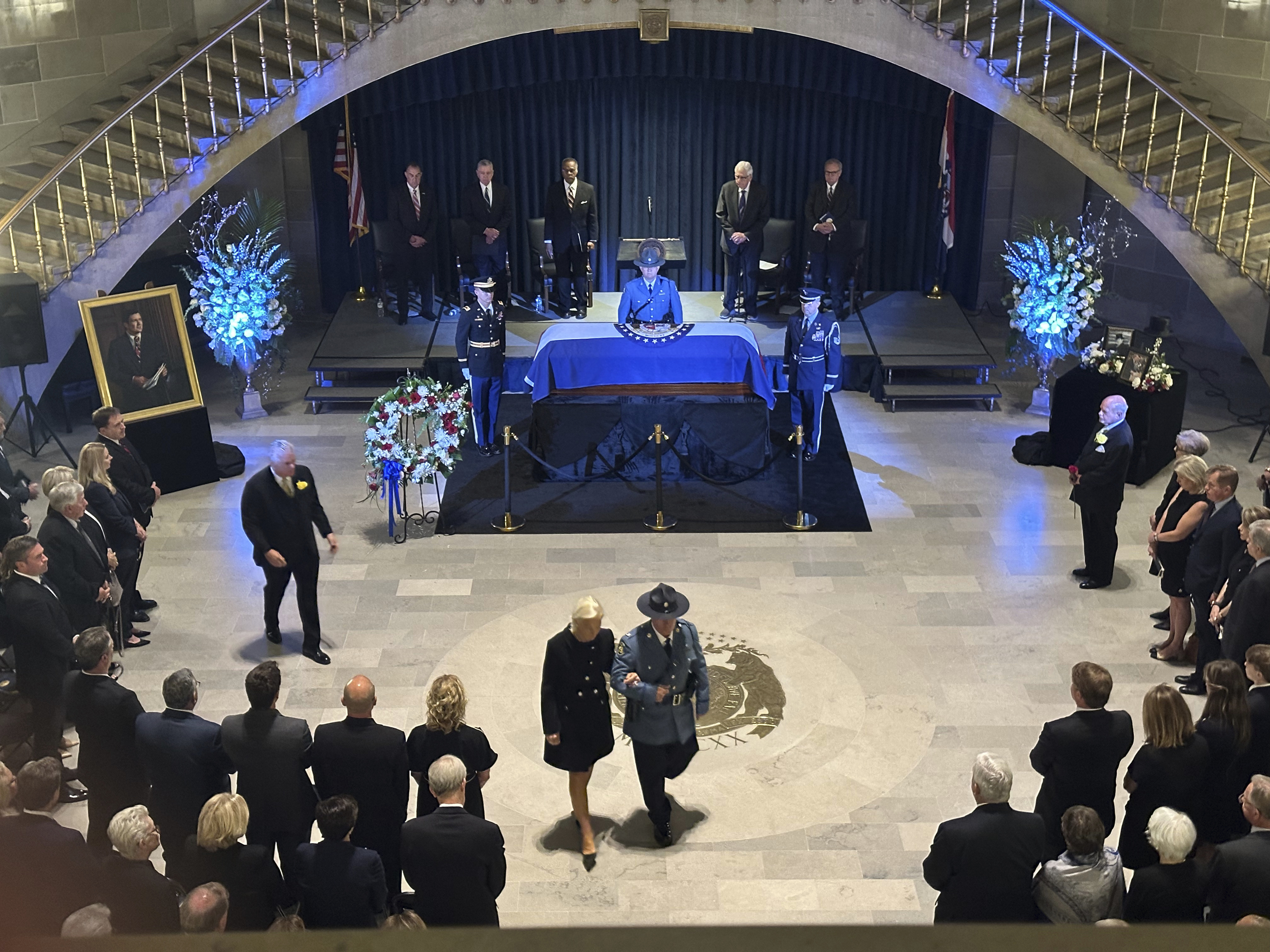 Linda Bond walks out of the Missouri Capitol Rotunda with an official escort after the memorial service for her late husband, former Missouri Gov. and U.S. Sen. Christopher Kit Bond on Tuesday, May 20, 2025, in Jefferson City, Mo. (AP Photo/David A. Lieb)